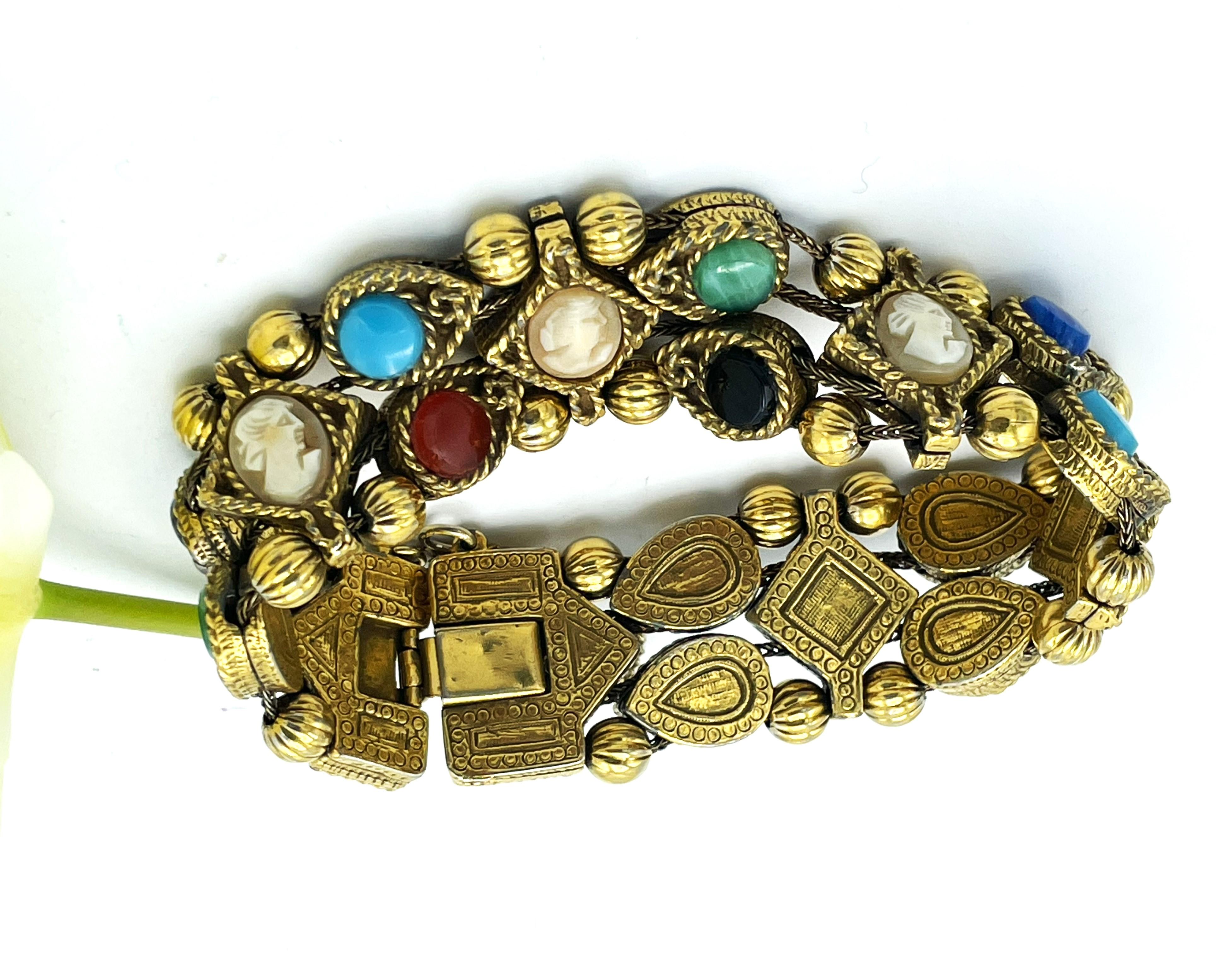 
3 rows of movable bracelets with gems and colorful glass stones. Gold plated, 1950s with Gems and colorful glass stones. 
I think it is modeled after the original ones made of real gold and gemstones.

Dimensions: 
Length of the bracelet 19