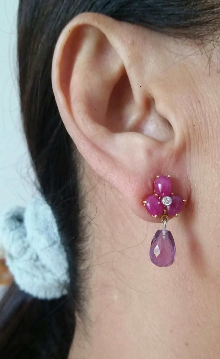 Simple elegant and completely handmade Earrings consisting of an upper part of 3 oval shape Ruby cabs of 4 mm x 5 mm set together in 14 Kt yellow gold with 2 small diamonds in the center, at the bottom 2 Round Drop Faceted Natural Amethyst measuring