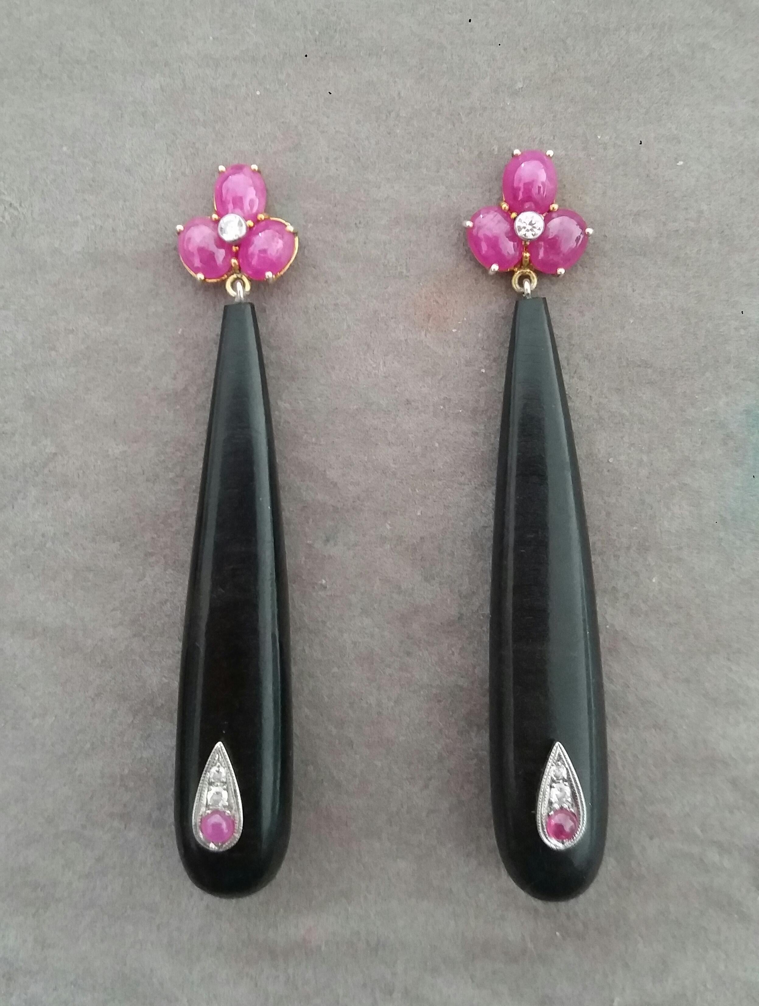 Elegant and completely handmade Earrings consisting of an upper part of 6 oval shape Ruby cabs of 4 mm x 5 mm set together in 14 Kt yellow gold with 2 small diamonds in the center, at the bottom 2 Ebony Round Drops measuring 11 x 55 mm with 2 small