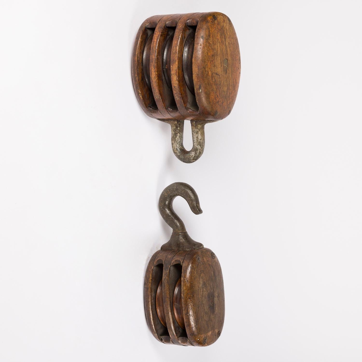 Three mid 19th century oak and iron Naval pulley blocks, used on sailing ships.

1: Double sheave tackle block with fixed eye. Height: 17 ½ inches.

2: Double sheave stiff swivel hook tackle block. Height: 20 inches.

3: Triple sheave tackle block.