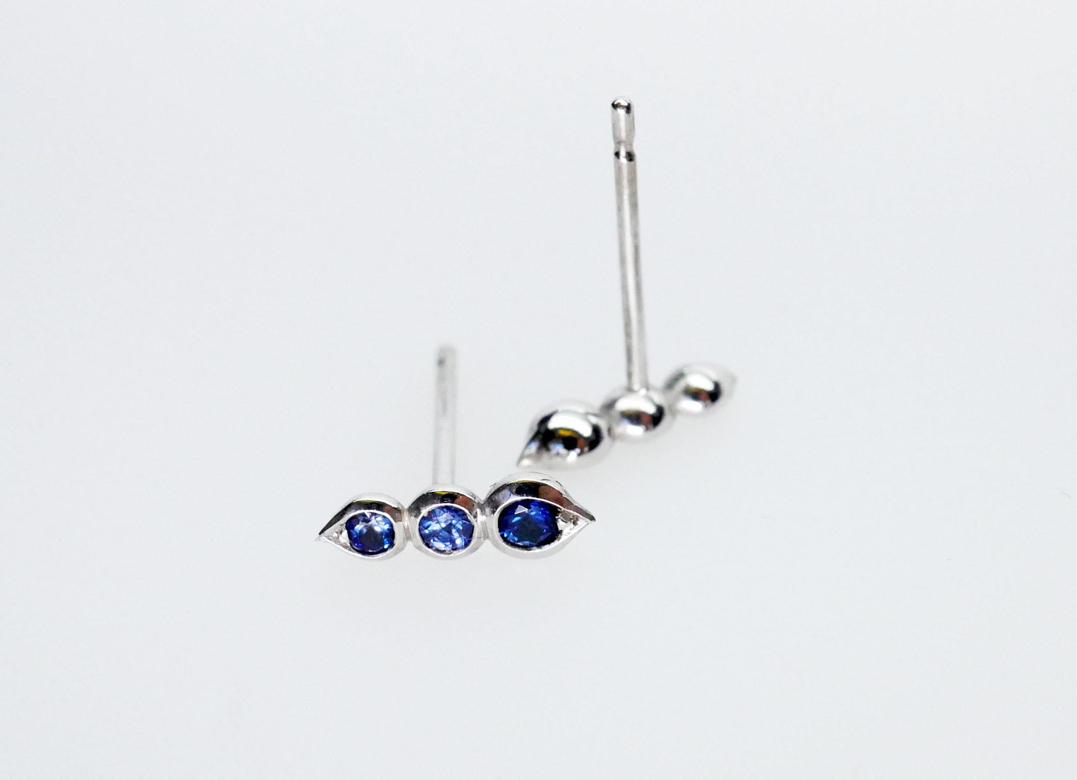 Beautifully hand crafted round blue sapphire stud earrings in 18k white gold. This blue sapphire trio sits in a delicate bezel setting with subtle tear drop shape at each end. Wear it alone or mix and match with other earring styles.

Total Sapphire