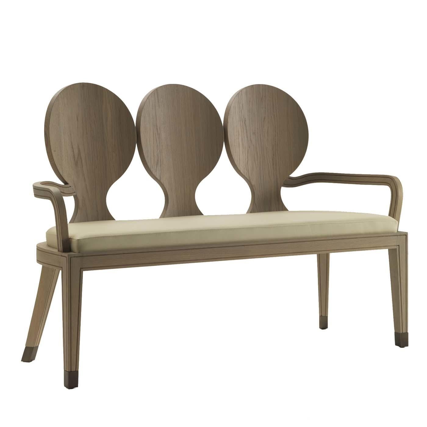 This unique design will enliven both a Classic and a contemporary interior. The ideal accent piece for an entryway, this three-seat bench was crafted of wood with a finish in natural oak and features saber-shaped back legs and low armrests. The