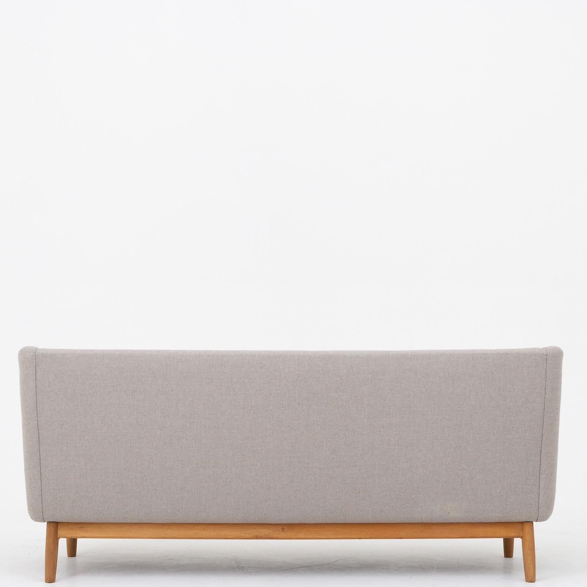 Reupholstered 3-seat sofa in Sunniva 2 fabric from Kvadrat (shell in code 717, seat in code 172)  with frame of oak. Maker Søren Willadsen.