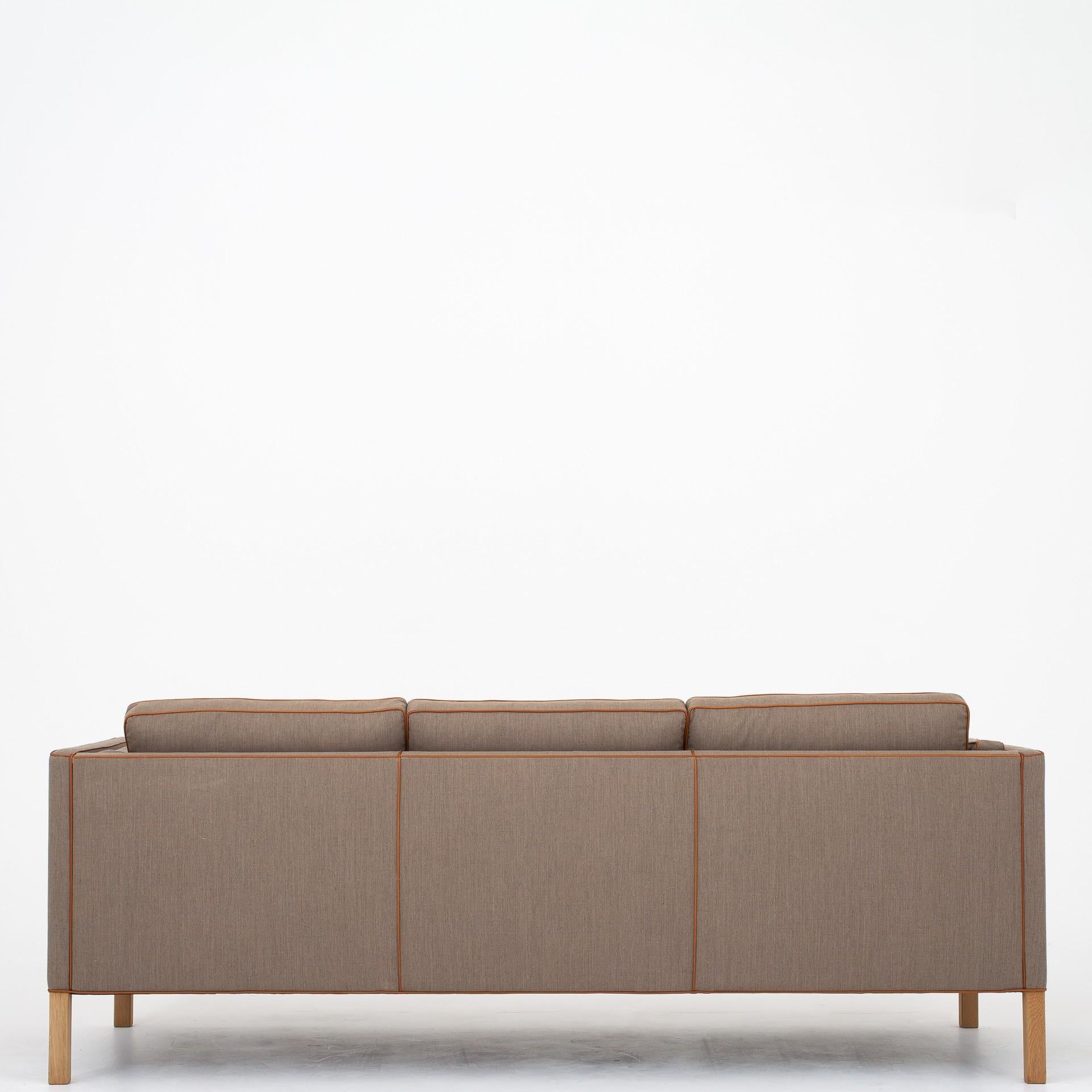 BM 2333, reupholstered 3-seat sofa in Remix 2 fabric (col. 233) and cognac leather. Legs in oak. Maker Fredericia Furniture.