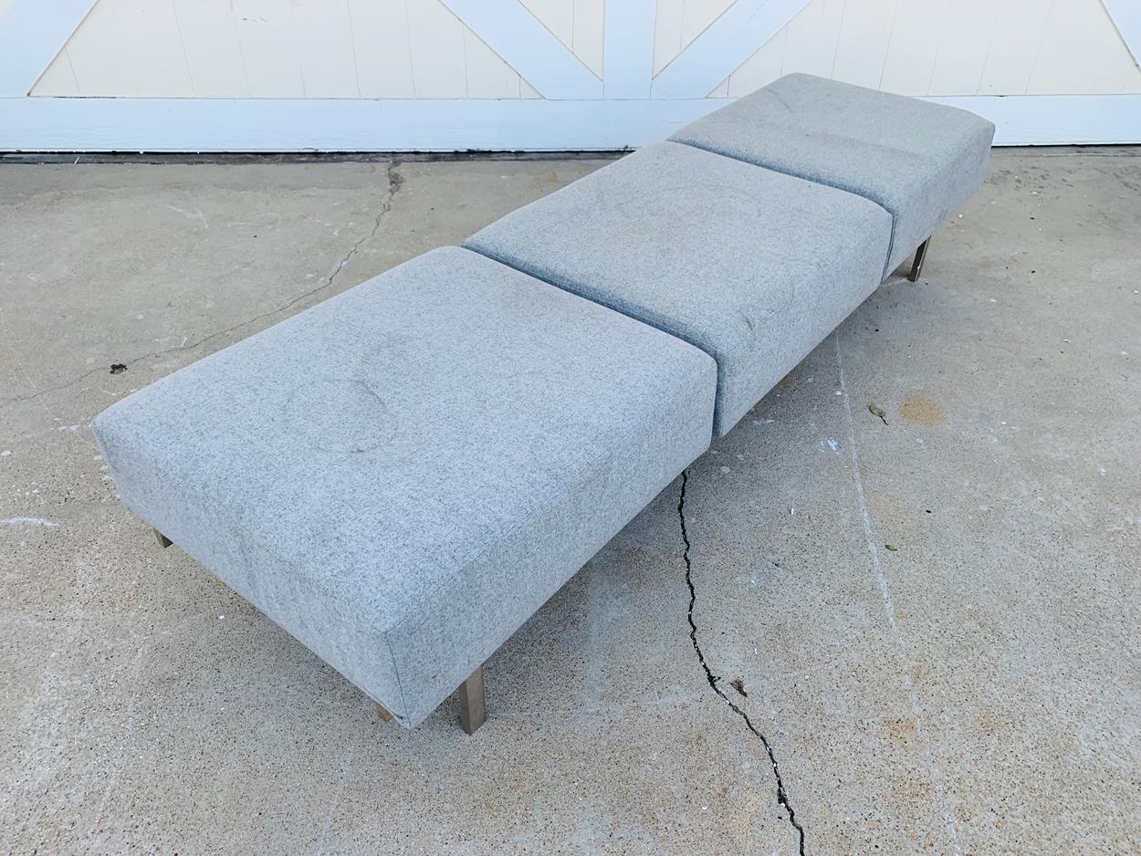 Beautiful and modern 3 seater bench made in Canada by Keilhauer and part of the Canal collection.

The bench is very well made, the base is made of stainless steel with a matte finish and upholstered in a gray fabric.
The metal looks great