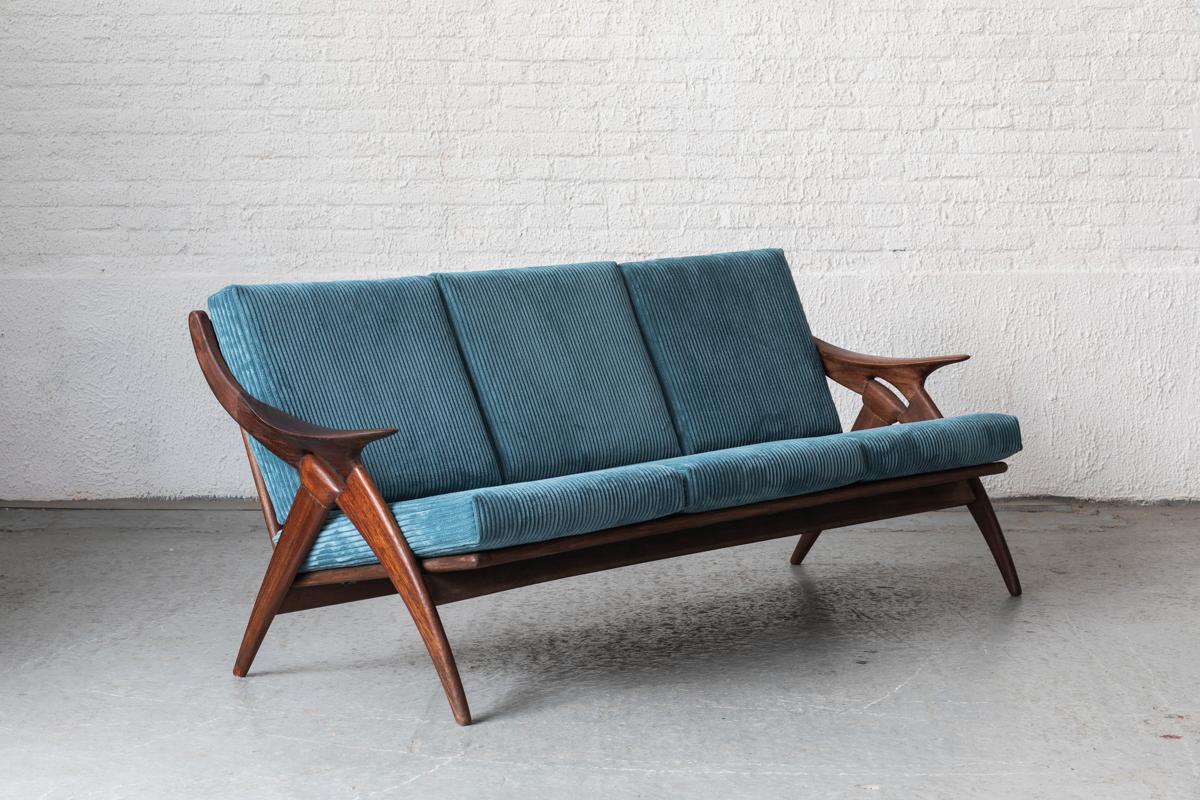 3-Seater ‘De Knoop’ designed and produced by De Ster Gelderland in the Netherlands, 1960s. The frame is made of organically sculpted, solid teak wood and it has newly upholstered cushions in blue corduroy. One leg is a bit chipped, as shown in the