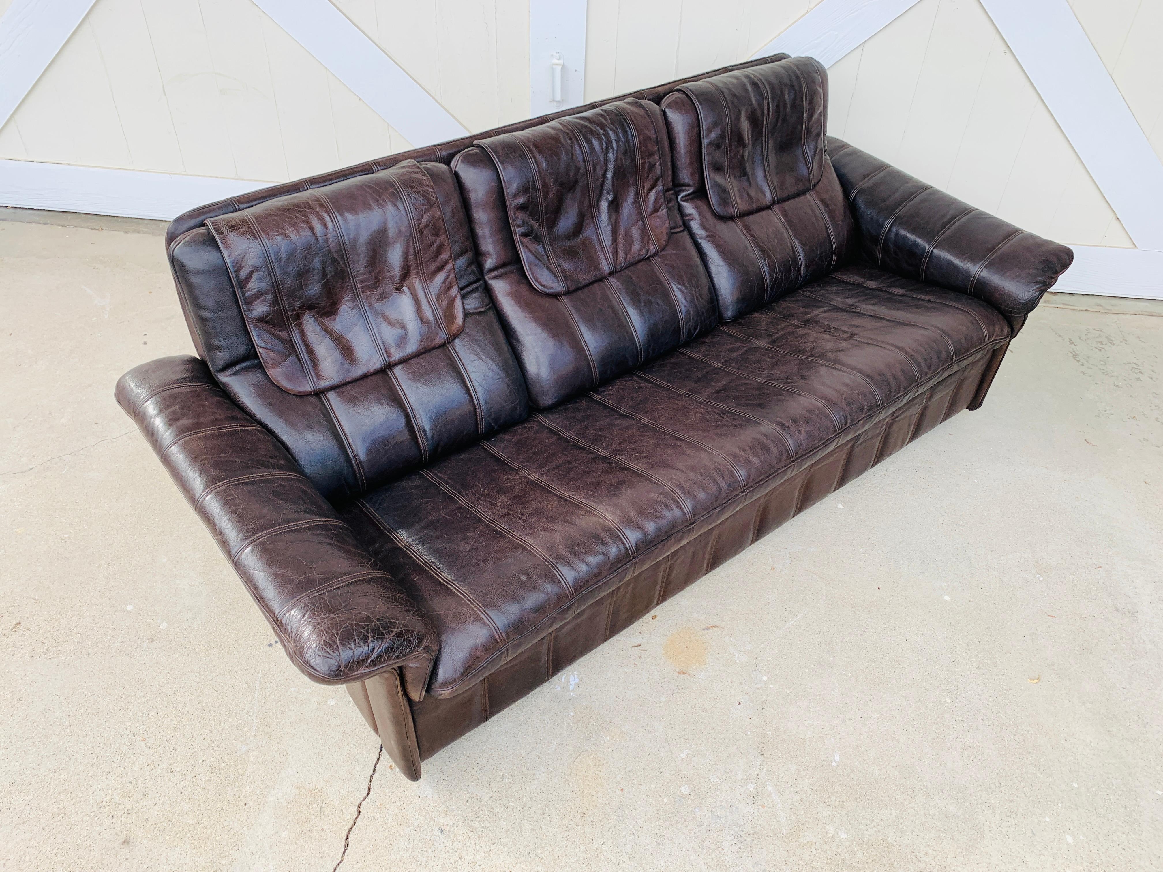 Vintage 3-seat sofa upholstered in brown leather designed and manufactured in Switzerland by De Sede.

The piece is all original and is in good vintage condition.

Measurements:
79 inches wide x 33 inches deep x 31 inches high x 16.5 inches
