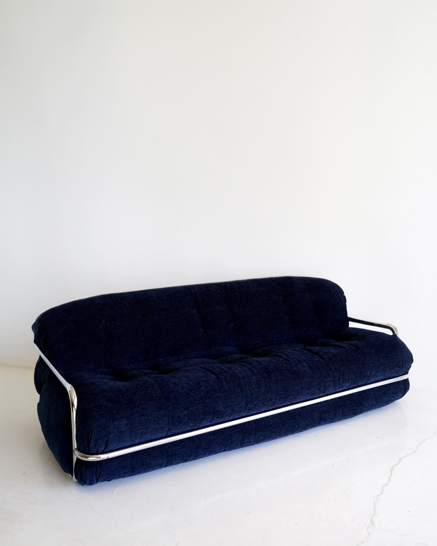 Low, curvy, and endlessly seductive 3-seat sofa by Mario Sabot. Stunning from all angles, this rarely seen model has been newly reupholstered in a beautiful deep blue woven velvet and is in excellent condition. Reduced shipping costs available for