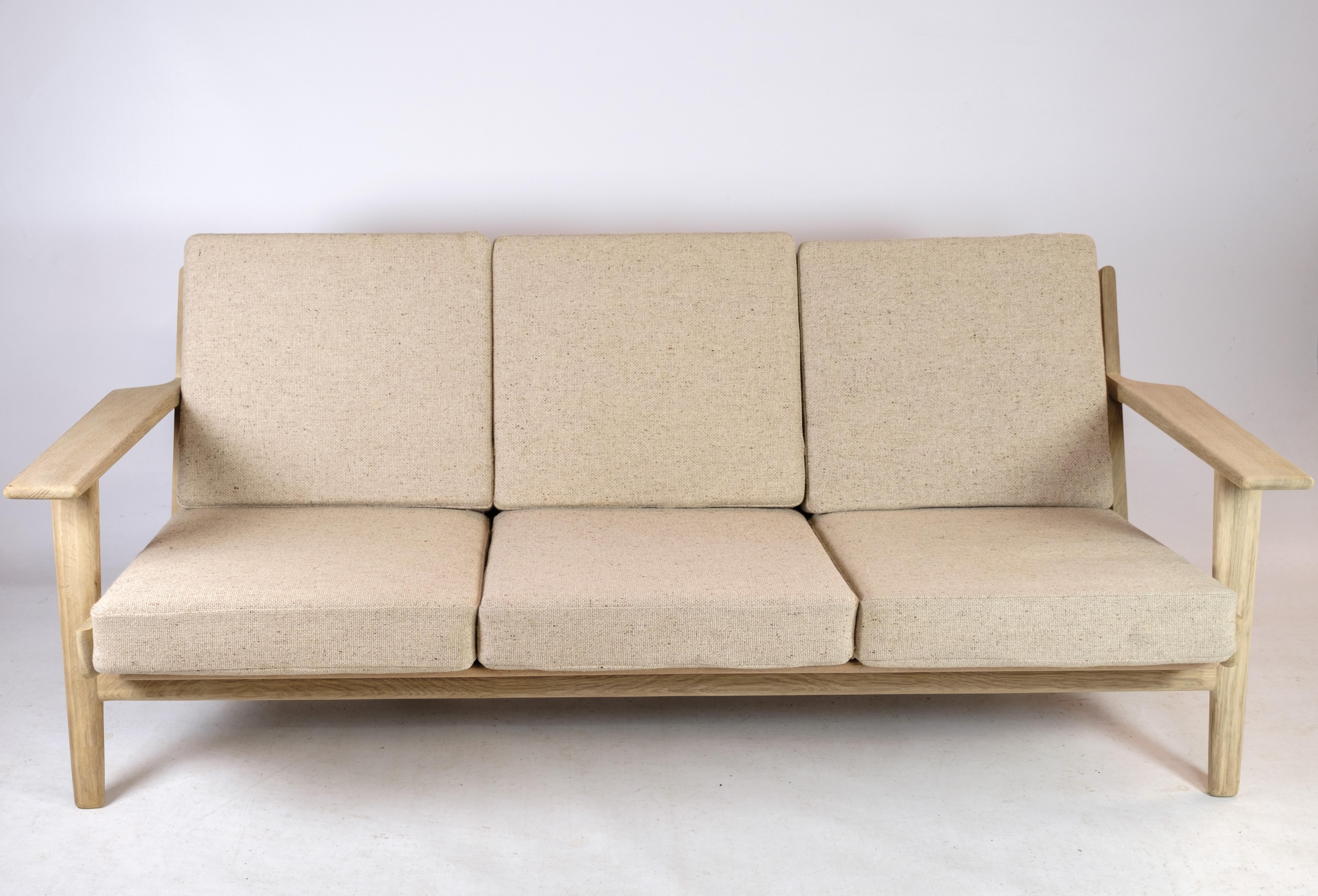 Model GE 290 is a 3-seater sofa designed by the famous Danish designer Hans J. Wegner in 1953. The sofa has a stylish oak frame and light fabric cushions, which gives it an elegant and timeless look. It is made from high-quality materials, which