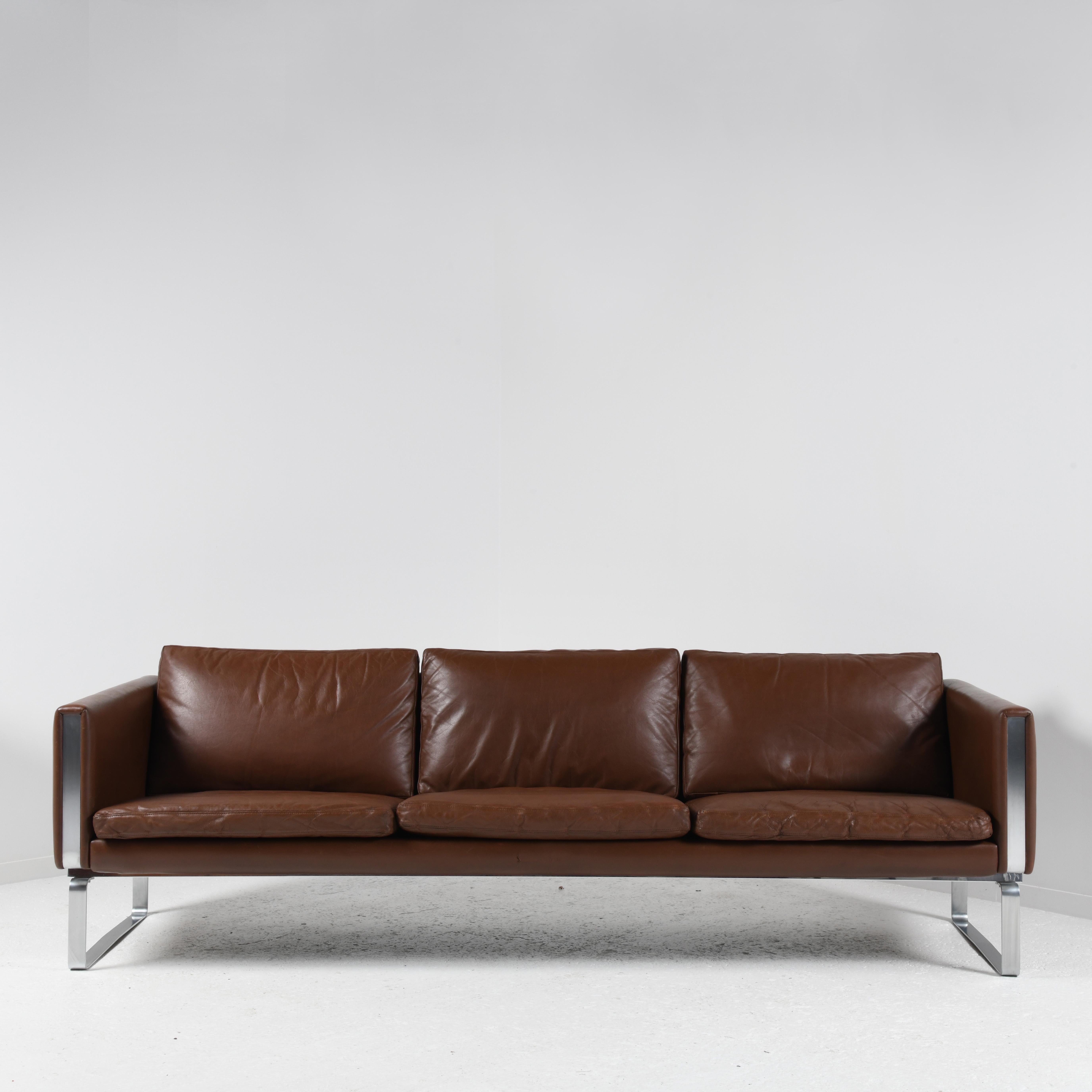 3-seater sofa model JH-803, designed by Hans J. Wegner (1914-2007) in 1970, published by Johannes Hansen in Denmark. Frame in brushed or chromed stainless steel and solid beech, upholstered in beige linen and brown leather. Leather cushions with