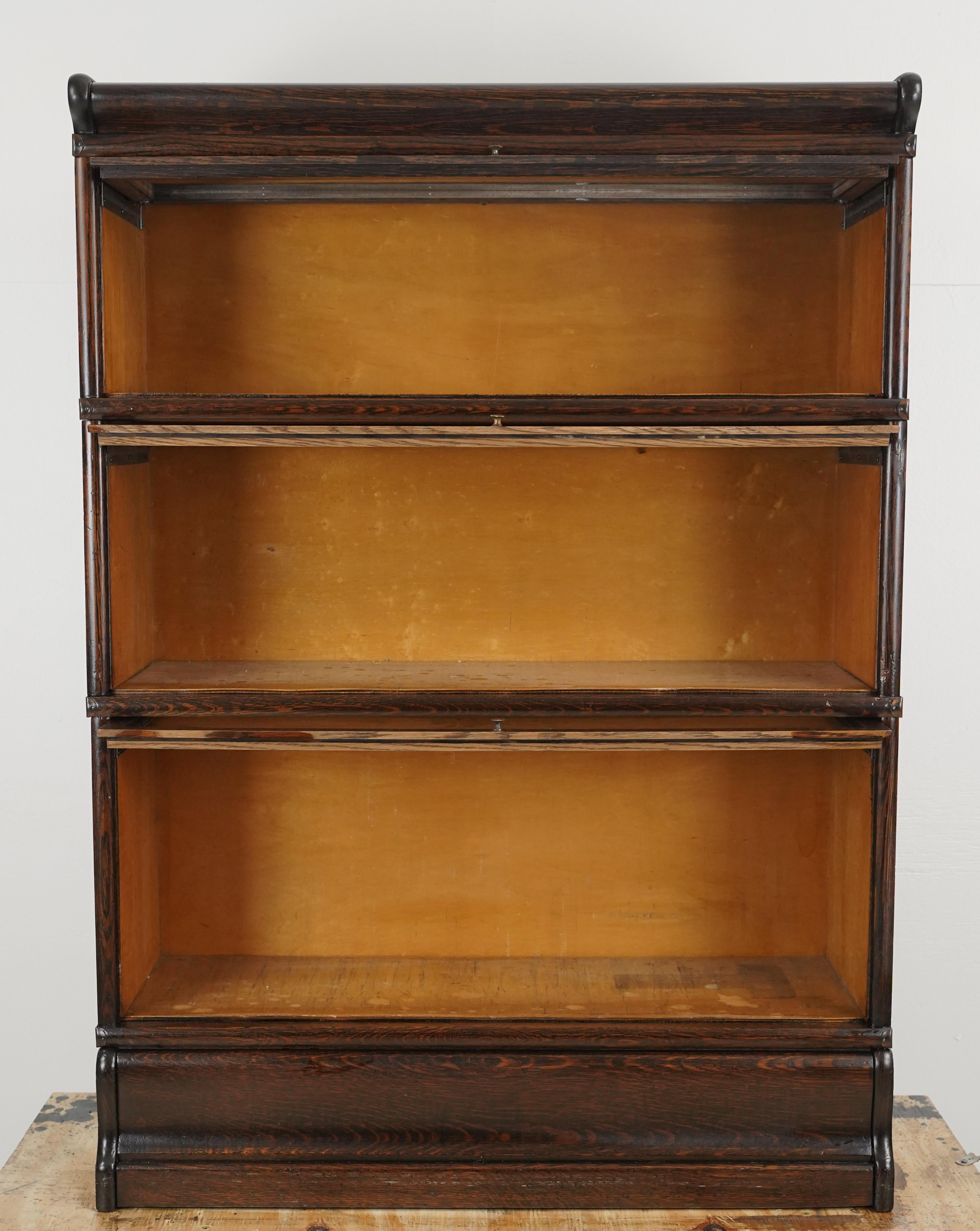 Grande libreria a tre sezioni in Oak con pomelli originali in ottone, base e piano a volute. Le librerie da barrister sono state originariamente progettate per i barrister o gli avvocati per conservare le loro biblioteche. Le librerie sono