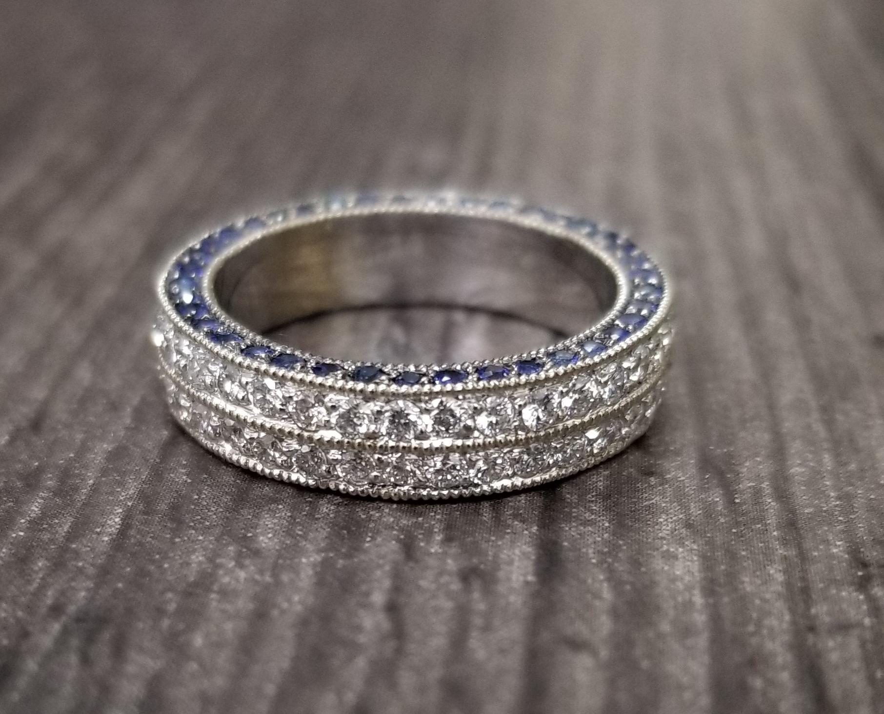 14k white gold ladies 2 row diamond pave eternity ring with sapphires pave in the side of the ring, containing 72 round full cut diamonds of very fine quality weighing 1.10cts. and 78 round blue sapphires weighing 1.00cts. ring size is 6, a new ring