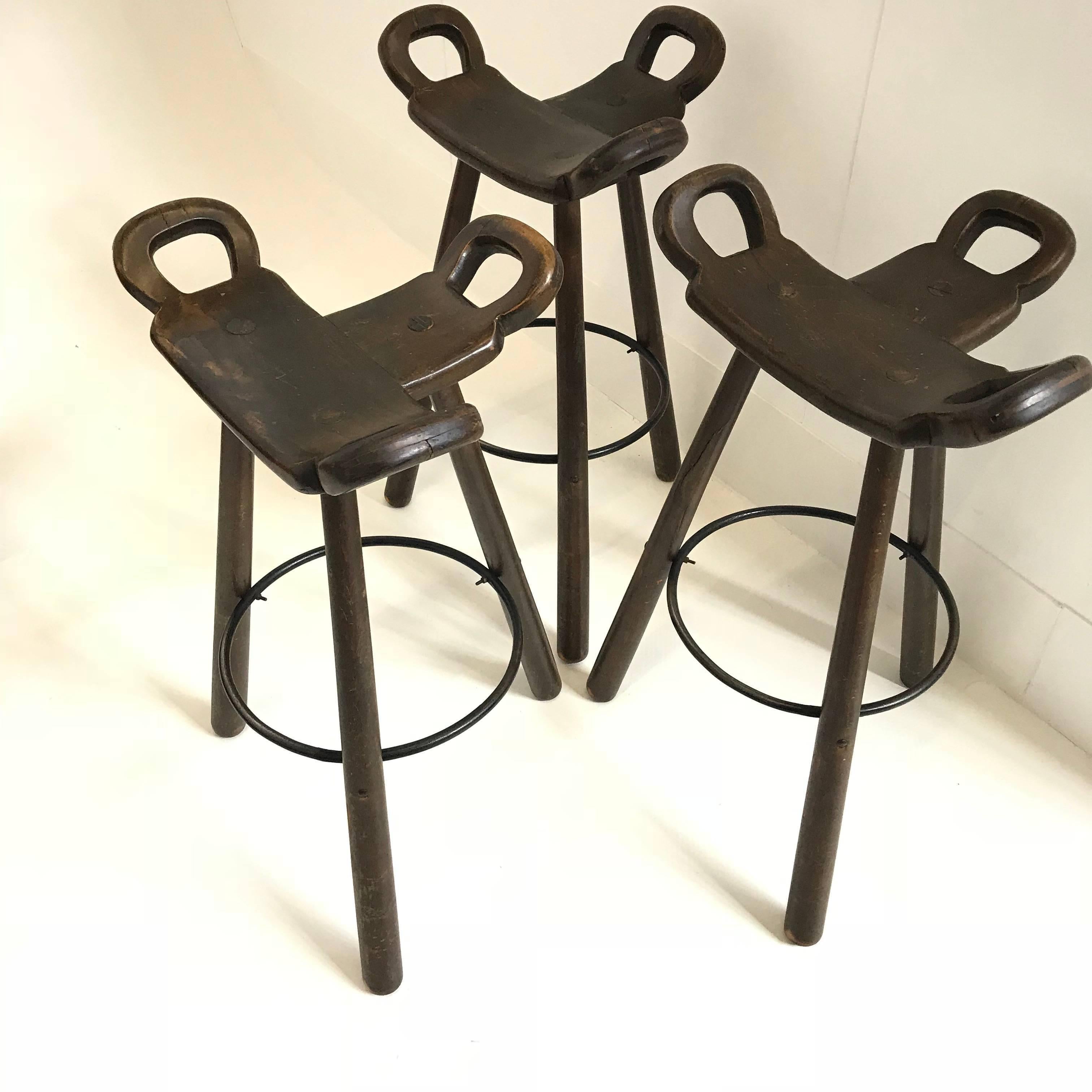 Set of three 'Brutalist' or 'Marbella' bar stools, in stained beech and metal, Spain, 1970s. A curved T-shape with three handles. The curved form makes sure the stool has a stabile seat, emphasized by the metal ring as footrest.
These bar stools