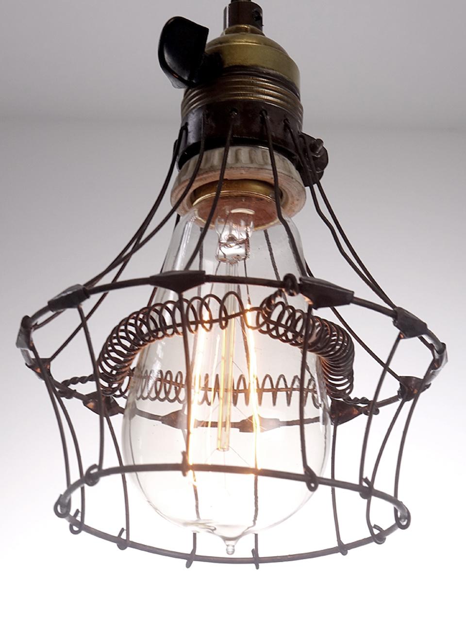 We love the basic simplicity of a protective wire cage over a bulb. Of all the early machine shop protective cages this is was one of the delicate and most interesting ever made. Look closely and you will see webbed joints where the wires cross as