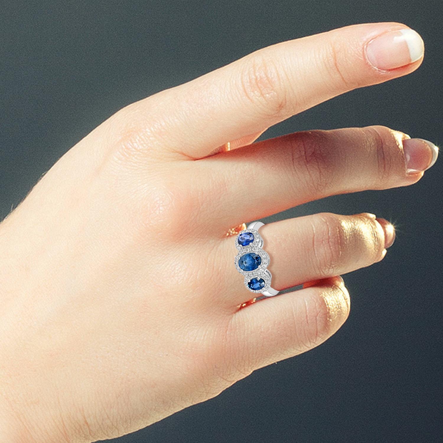 Cet élégant anneau met en valeur trois saphirs bleus de Ceylan vibrants en son centre, offrant un éclat de couleur audacieux et un attrait intemporel. Montée en or blanc 18 carats poli et rehaussée de 0,38 carats de diamants, la bague présente un