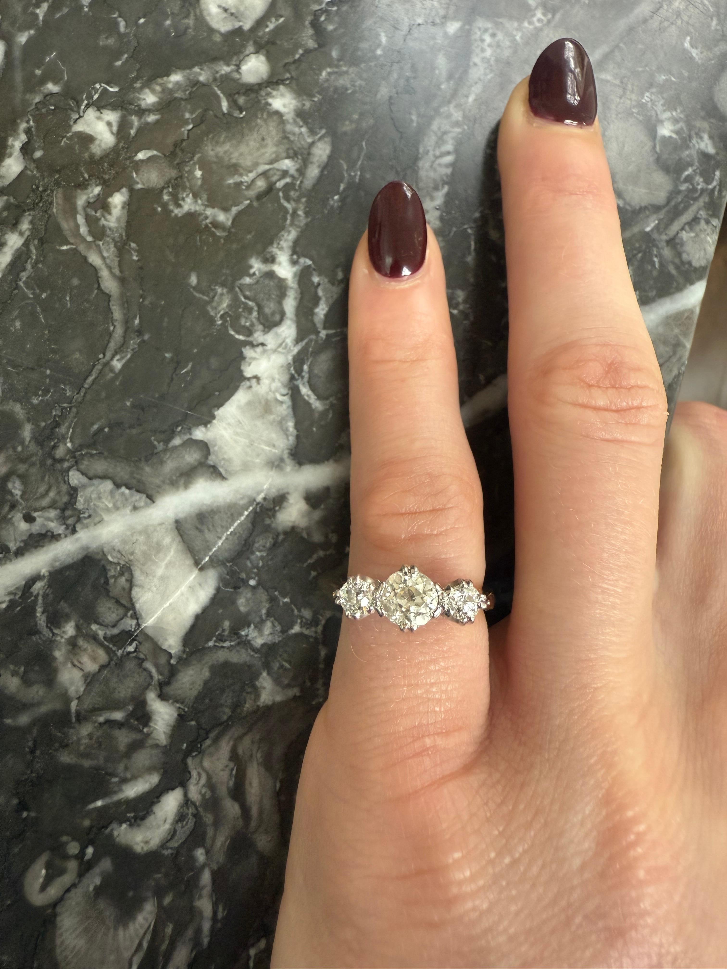 Une bague intemporelle du début du 20e siècle à trois pierres en diamant. Réalisée en or jaune 18ct, cette pièce présente trois diamants gradués de taille ancienne, la pierre centrale pesant environ 0,5 carat et le poids total des diamants étant