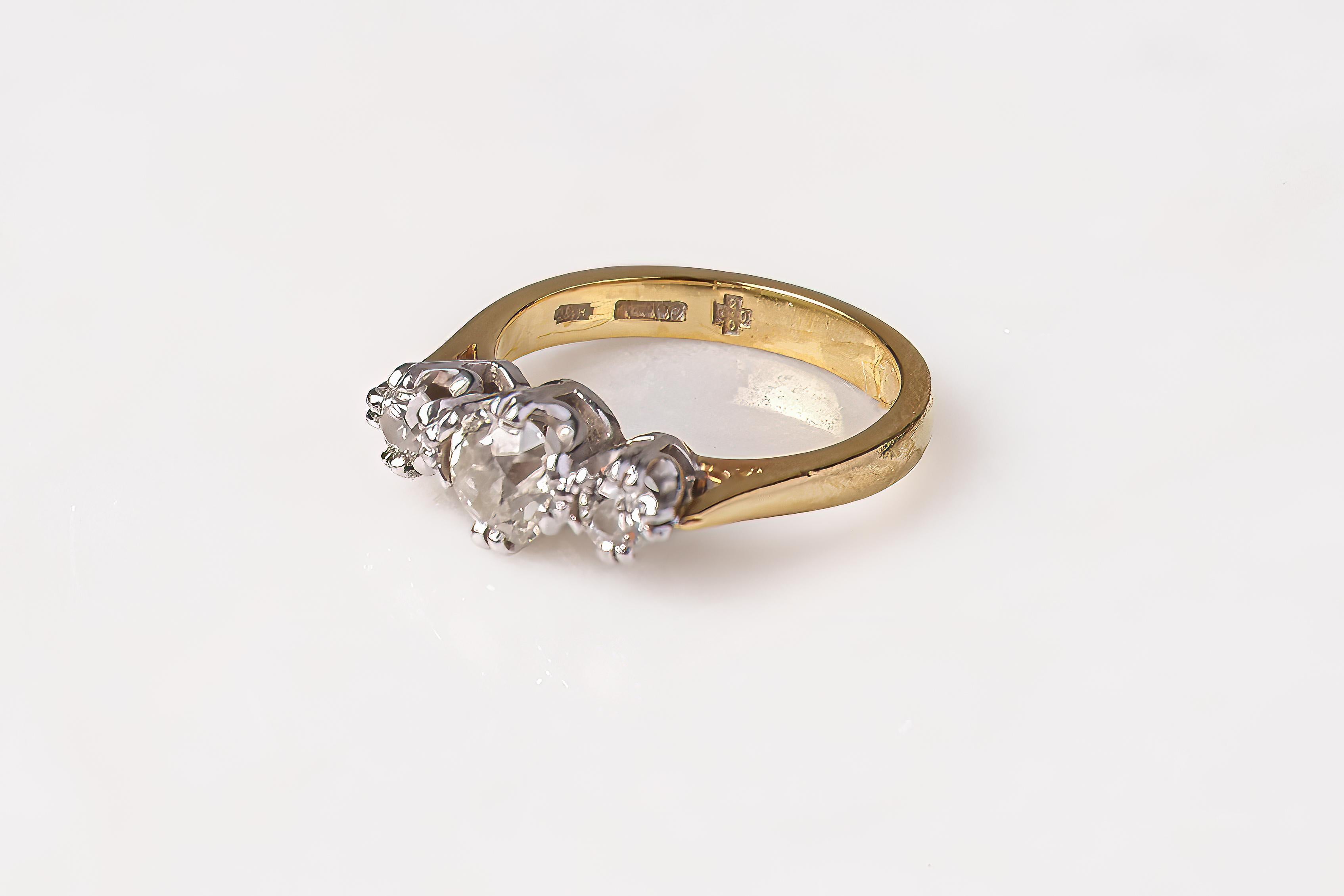 A timeless early 20th century three-stone diamond ring. Crafted in 18ct yellow gold, this piece features three graduated old-cut diamonds, with a central stone weighing approximately 0.5 carats and a total estimated diamond weight of 0.85 carats.