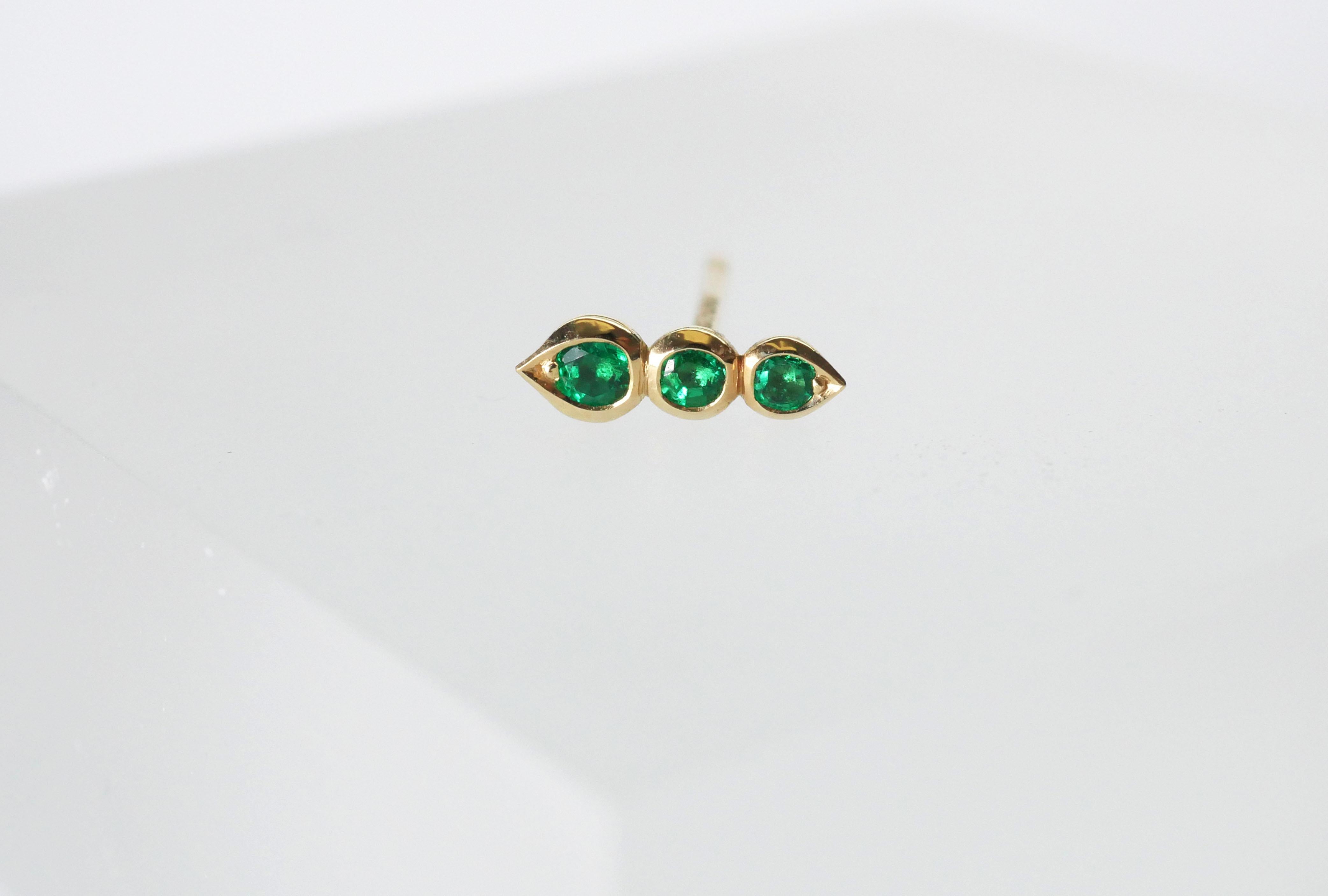 Beautifully hand crafted round emerald single stud earrings in 18k yellow gold. This emerald trio sits in a delicate bezel setting with subtle tear drop shape at each end, and is sold as a single stud earring to be worn solo or stacked.

Total