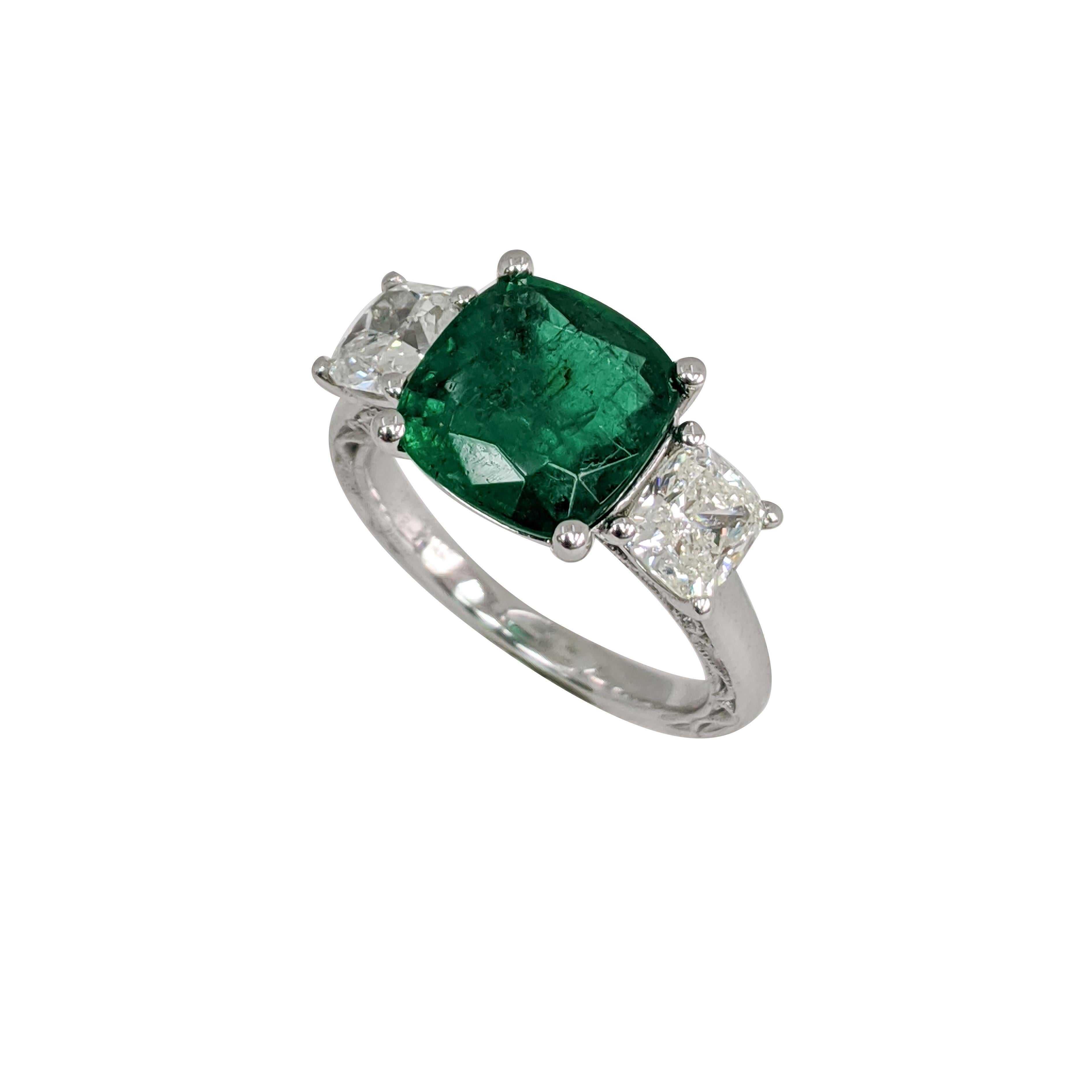 3 stones - One emerald cut emerald, two cushion diamonds. Ring made out of platinum. Art-style is fancy, 16th century. 

1.43ct Cushion Diamond
3.33ct Emerald
