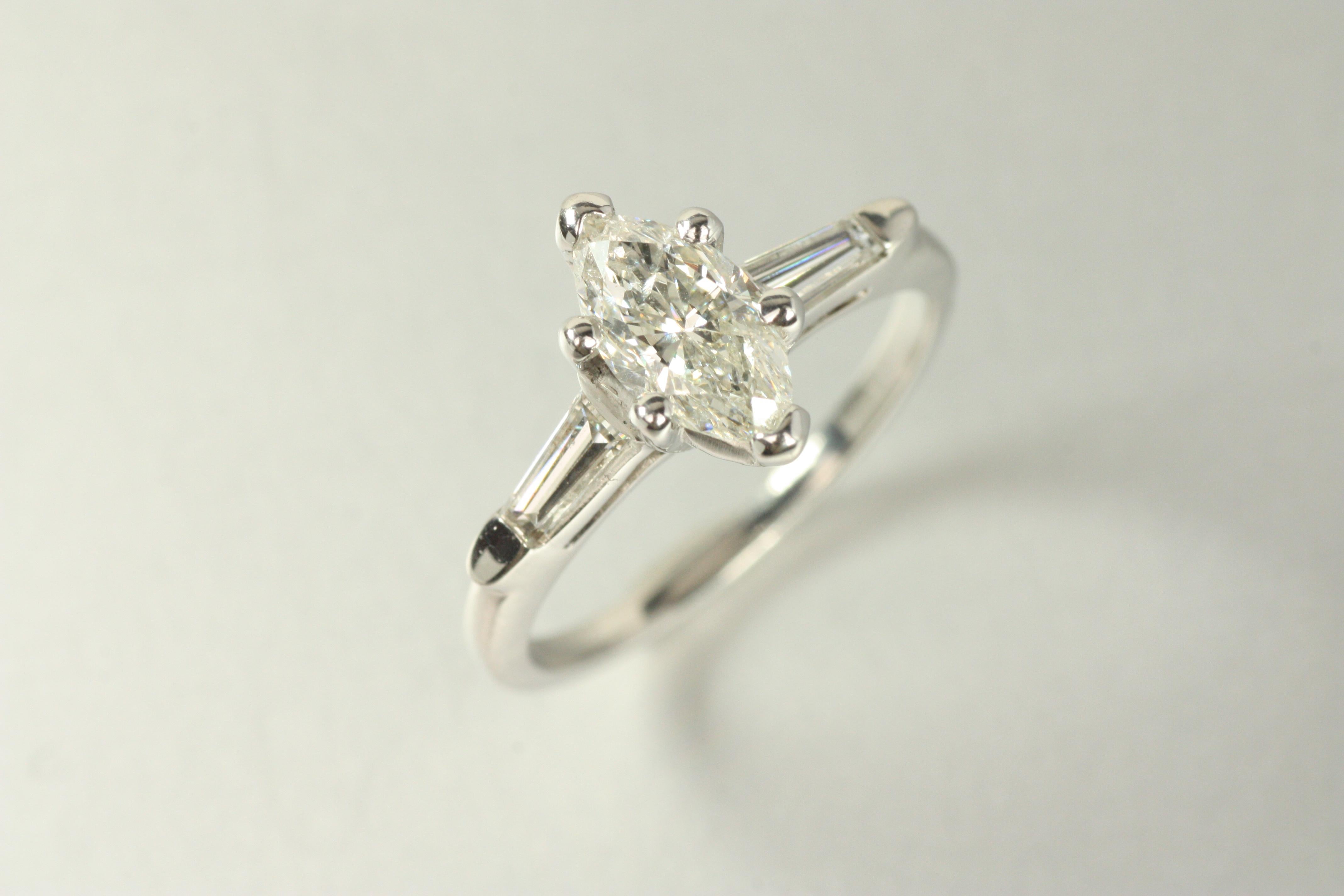 With its distinctive silhouette, this platinum 3-stone engagement ring highlights a 0.87ct marquise cut diamond. The elongated shape flatters the finger, while tapered baguette diamonds add a sleek, balanced touch. A ring that blends vintage charm