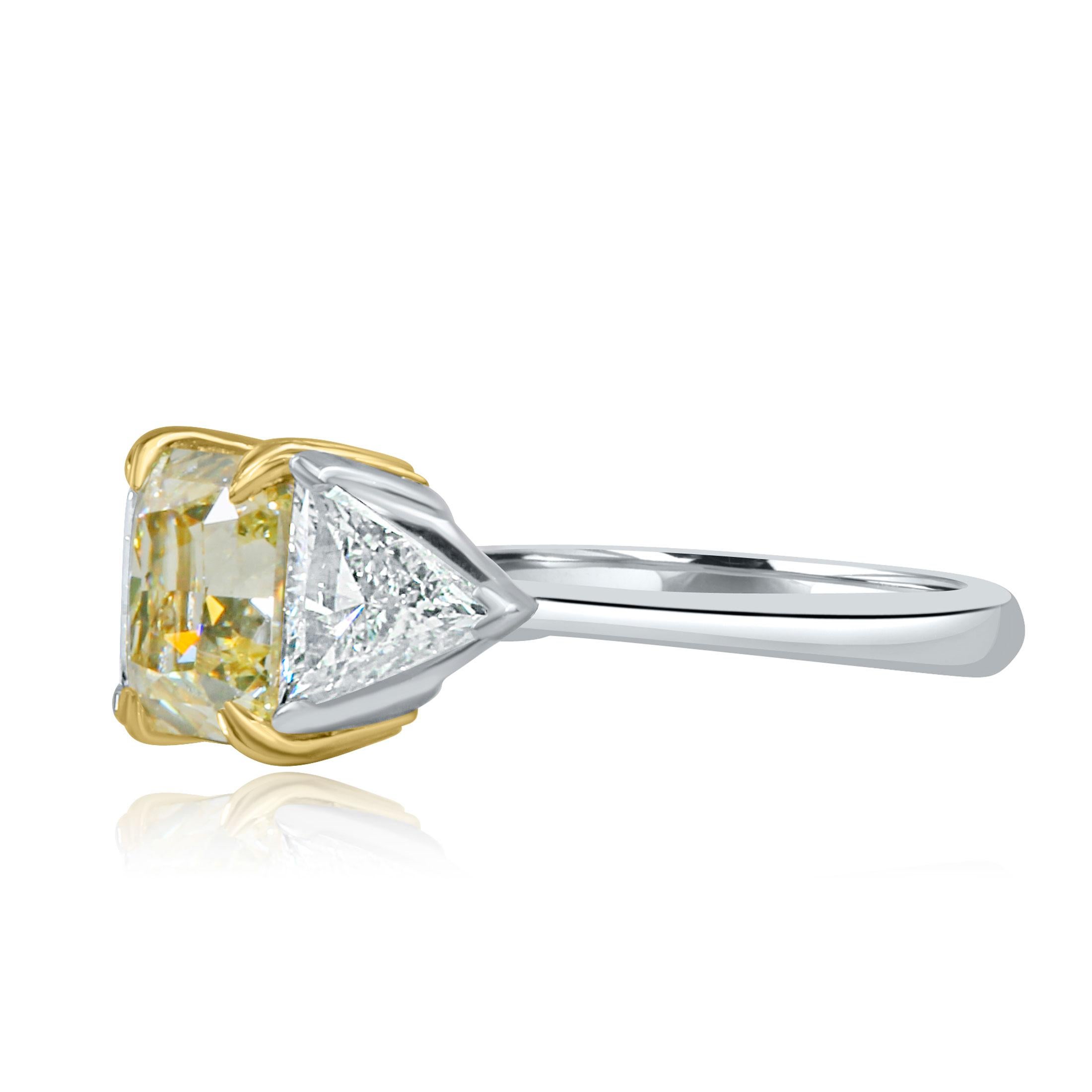 Véritable symbole de l'amour éternel, cette bague de fiançailles à trois pierres en diamant incarne magnifiquement le voyage de votre relation. En son cœur se trouve un magnifique diamant jaune clair certifié GIA de 2,13 carats de taille rayonnante,