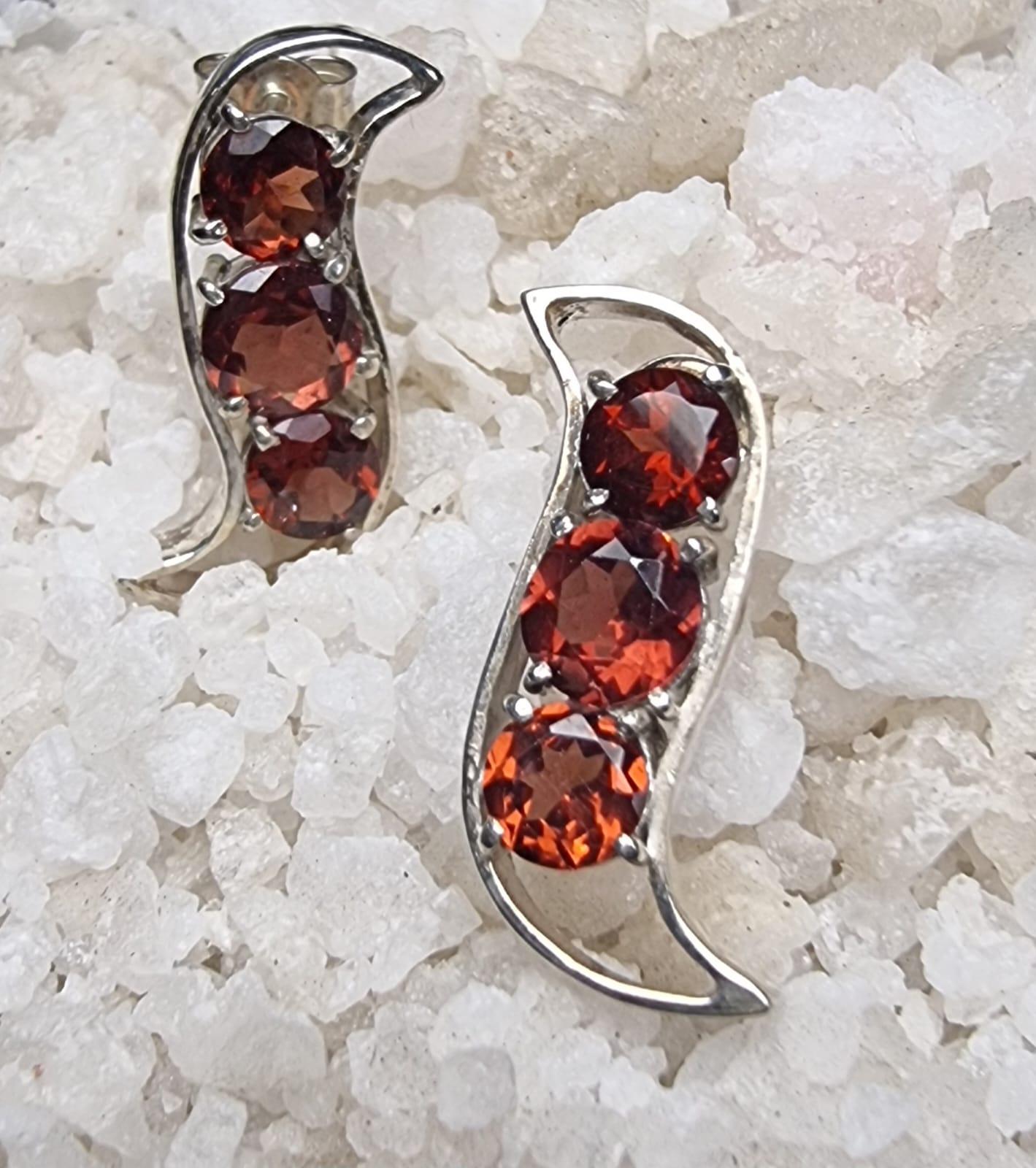 Introducing our exquisite 3 Stone Red Garnet Stud Earrings—a captivating fusion of elegance and nature's charm. Crafted in the shape of a pod, these earrings encapsulate the essence of growth and renewal, with three vibrant garnets symbolizing the