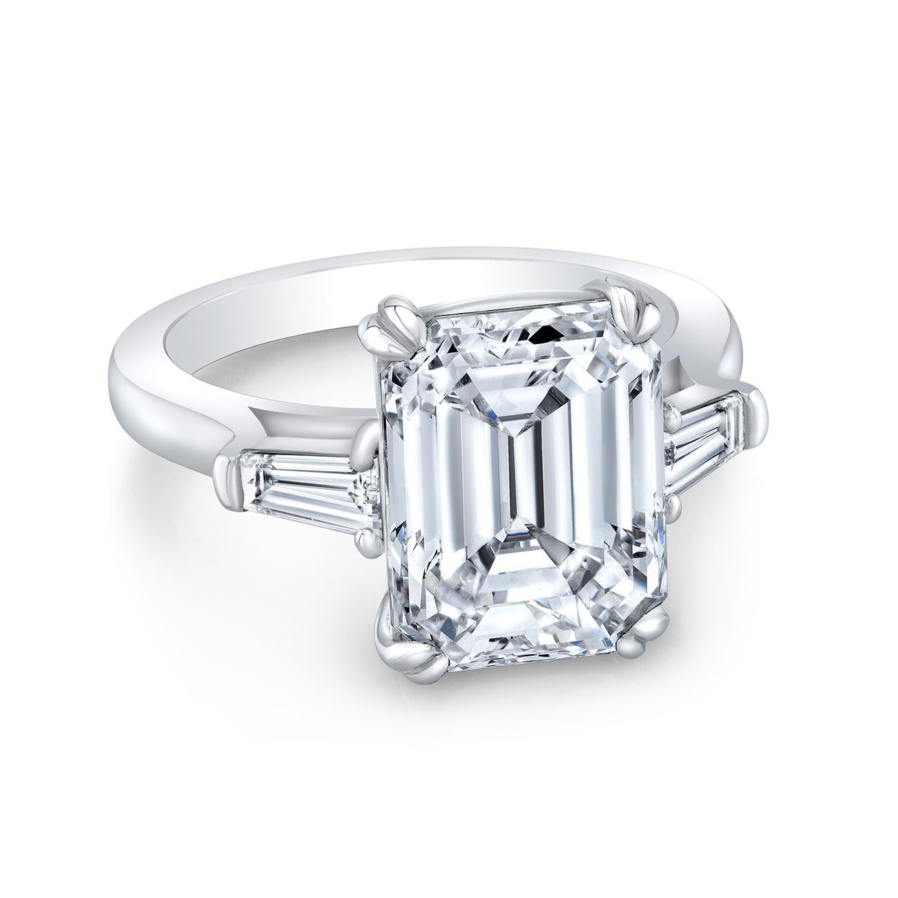 Three stone ring in platinum with GIA certified H/VS2 emerald cut center and channel set tapered baguette side stones. D6.50ct.t.w. (Center - 6.02ct.)