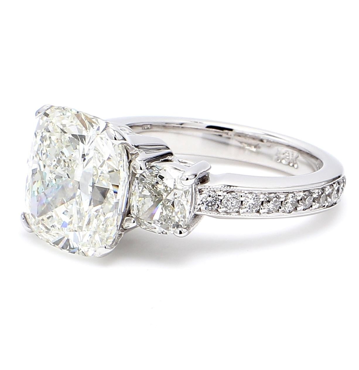 Anello a tre pietre in oro bianco 18 carati con centro con taglio a cuscino J/SI2 certificato GIA, pietre laterali a cuscino incastonate e diamanti rotondi incastonati sul gambo.  D8.19ct.t.w.  (Centro - 6,02ct.)