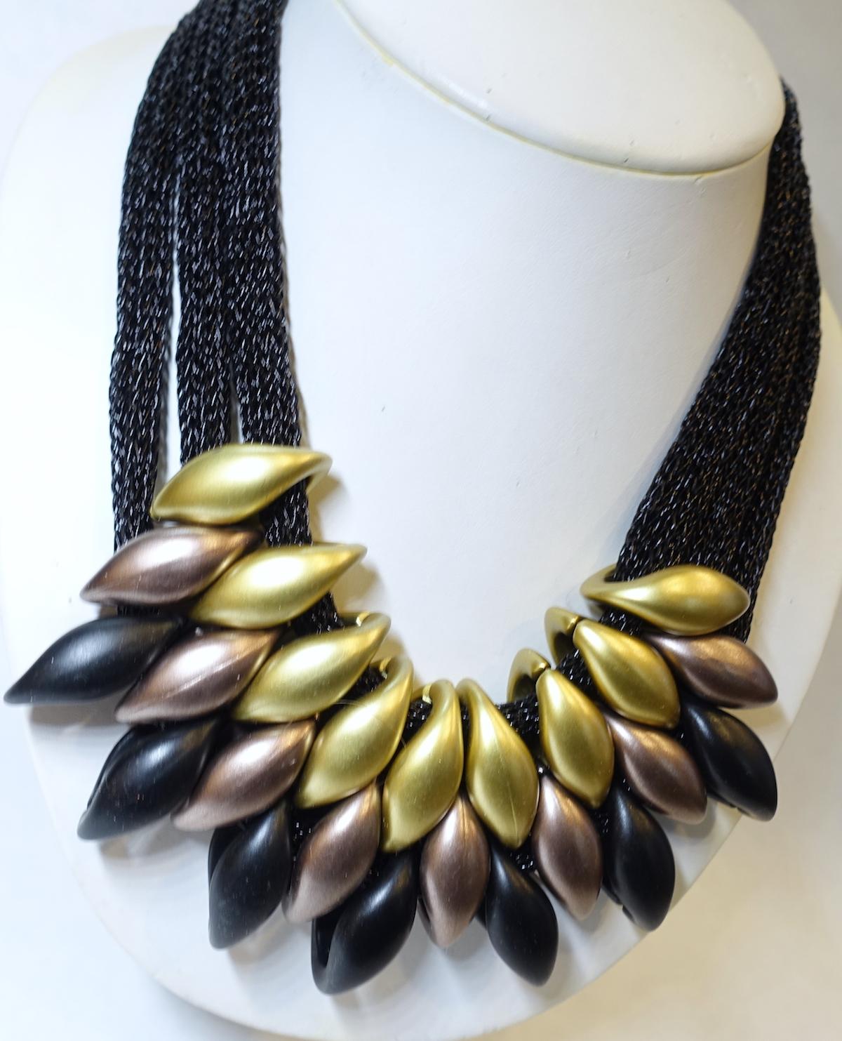 I just loved this necklace.  It’s so unique. This necklace has 3 rows of woven black threads leading down to gold, black and dark copper resin marquis shaped drops overlapping each other. The necklace measures 22” long with a spring clasp and each
