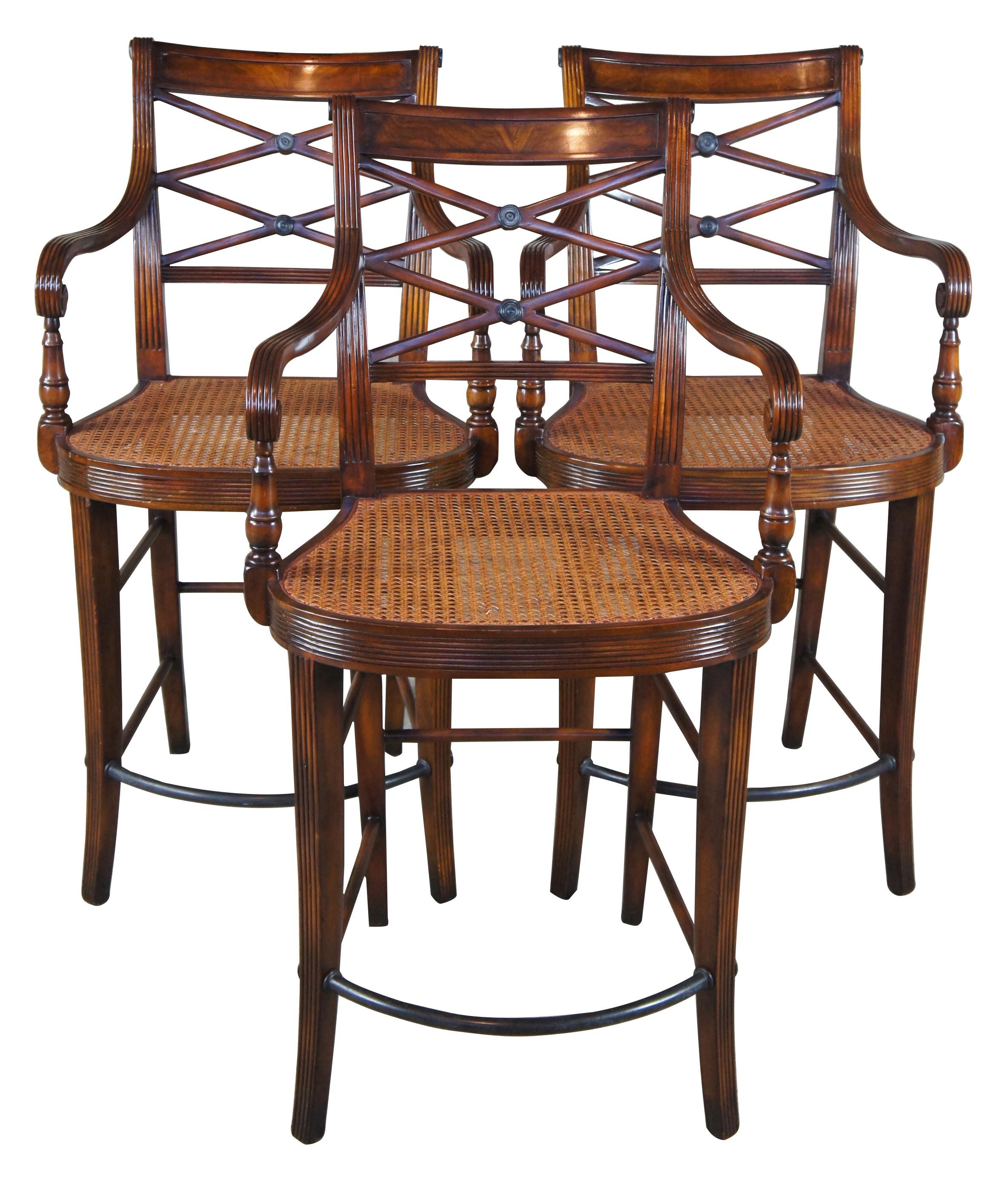 Theodore Alexander counter height bar stools # 4100. Features a hand carved armchair with reeded decoration, over scroll and double 'X' pierced back above a cane seat with upholstered down filled cushion. The chairs are made from mahogany and