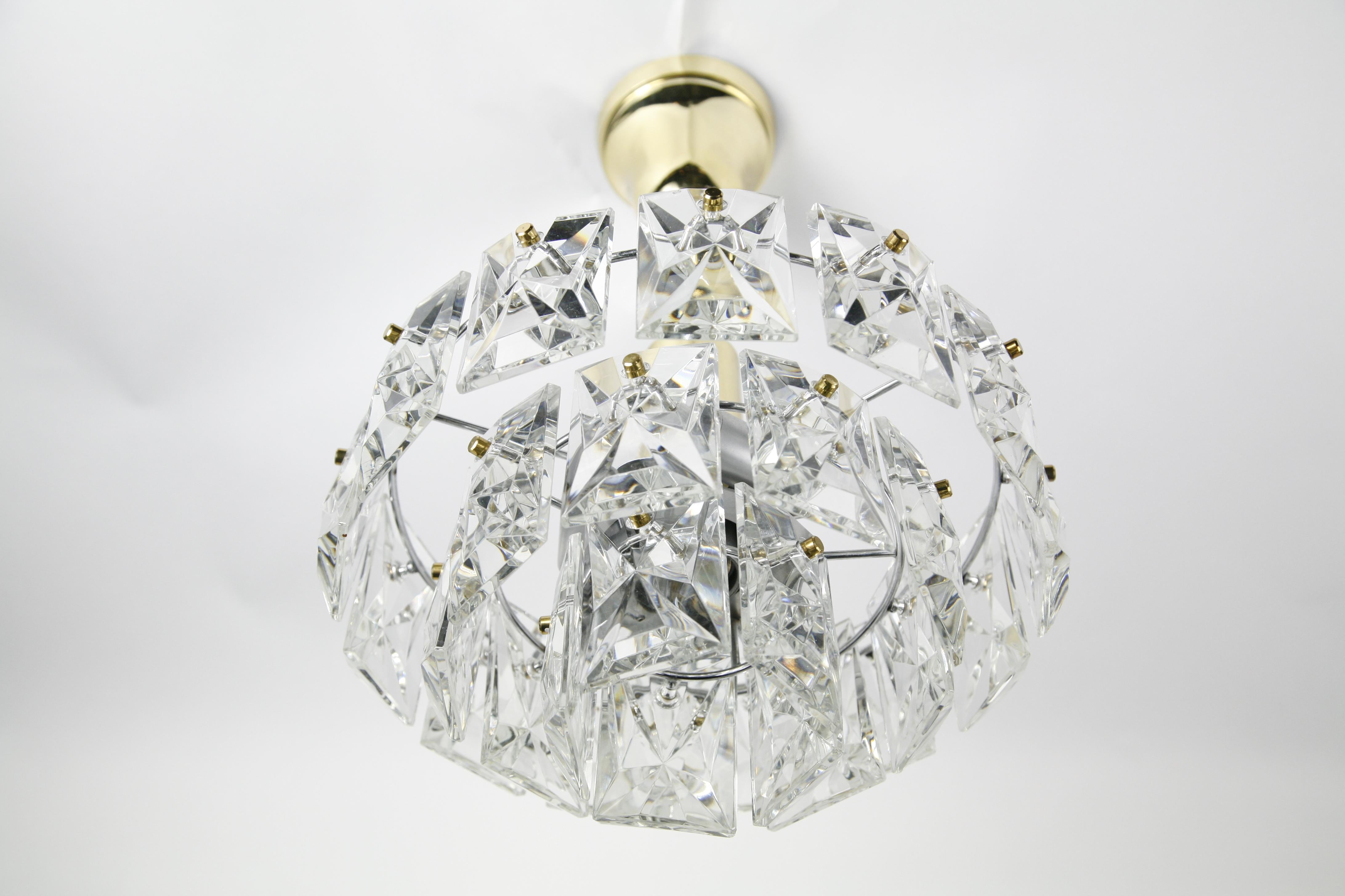 Crystal Kinkeldey Chandelier Chrome and Brass Frame, Germany, 1960, 3-tier diamond cut crystals it has one downward light and 3 sideward lights that illuminates the crystals, finials are in brass as well as the canopy and stem.


 