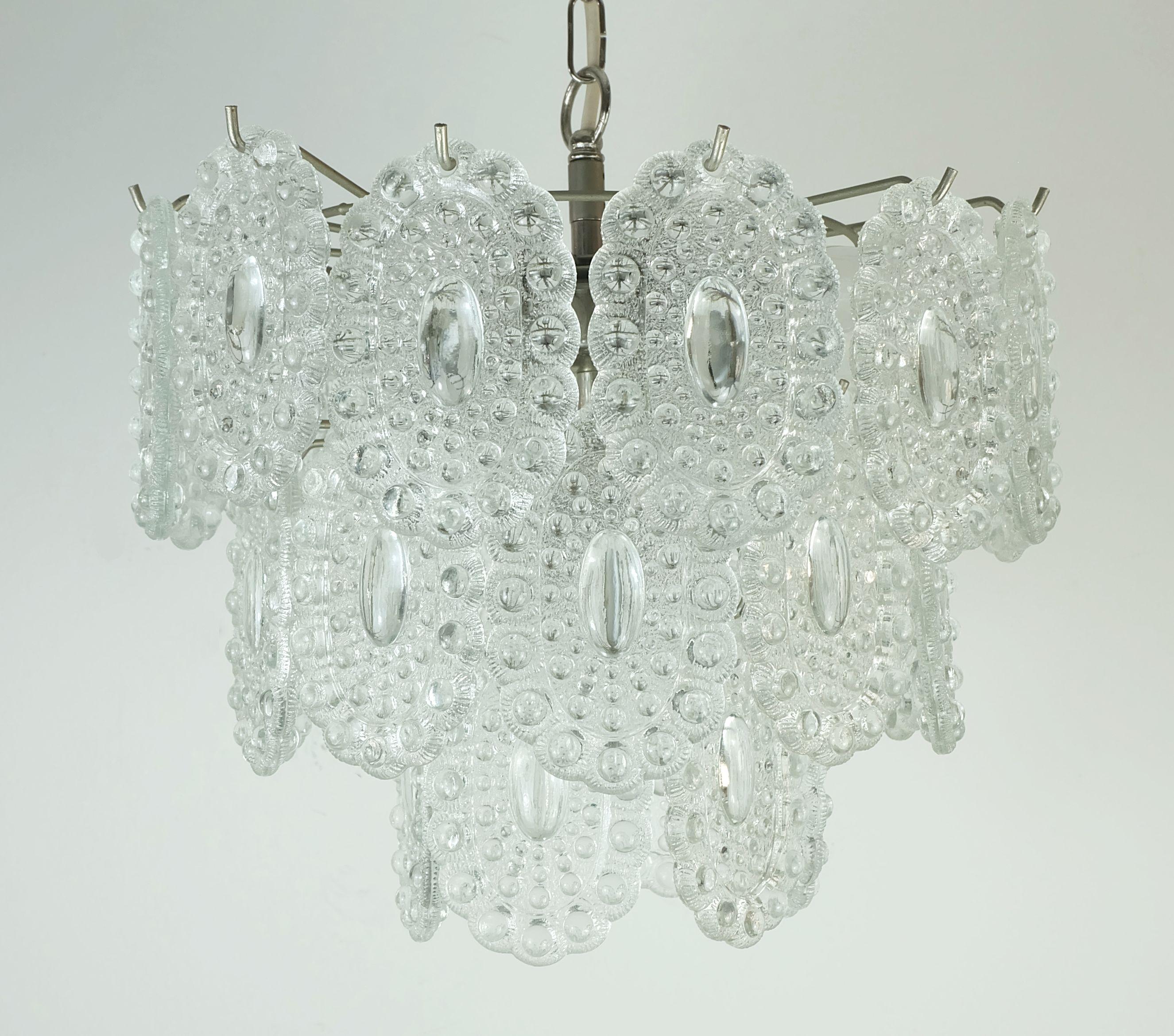 Beautiful vintage glass chandelier / hanging lamp from the 1960s to 70s with 29 oval glass discs with a textured surface. The frame is made of silver-colored metal. At the bottom in the middle there is a socket for an E27 light bulb, above it in a