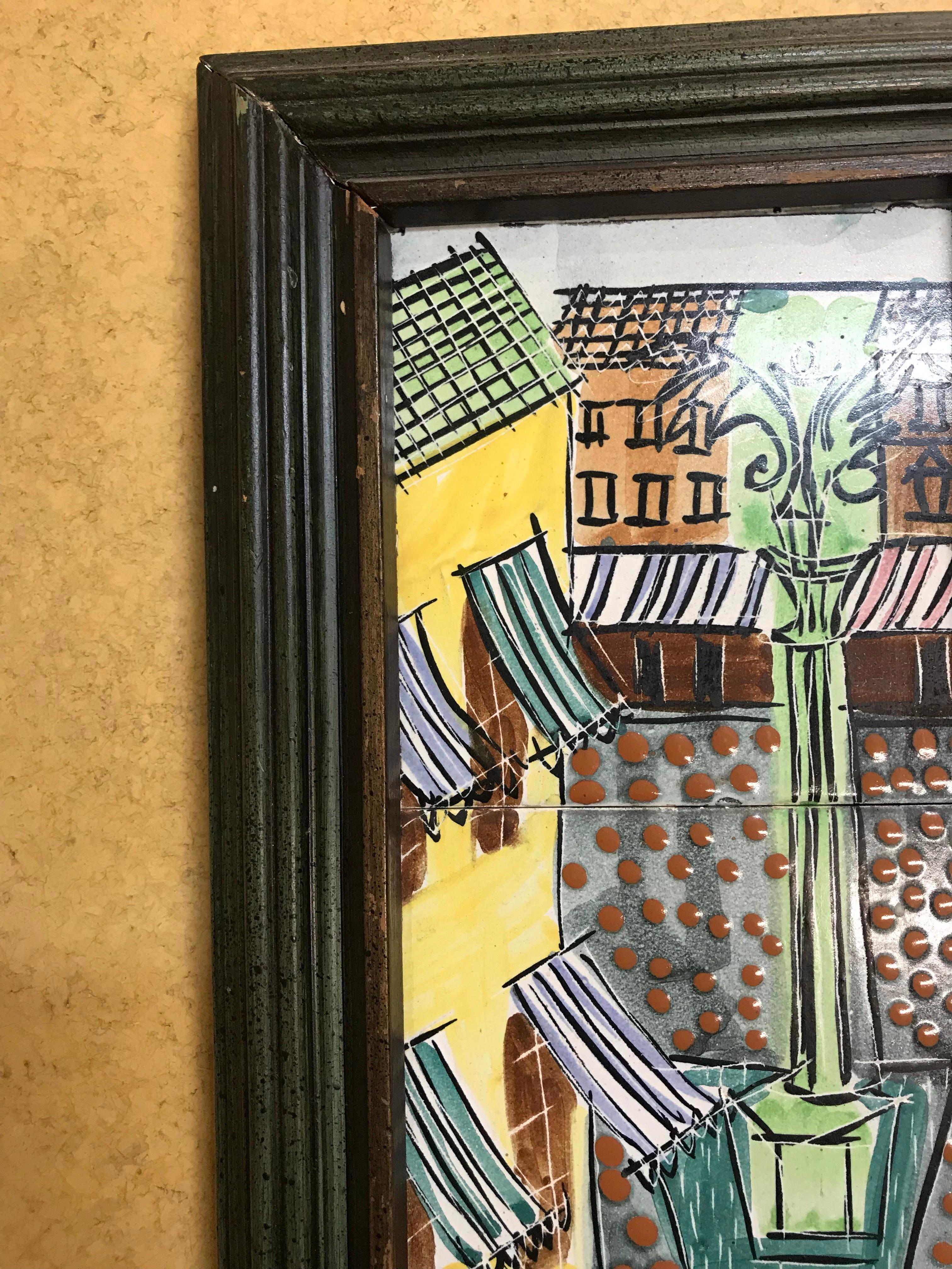 Cafe street scene in green, yellow, blue, and brown glazes. Early tile done by Harris Strong in original frame.