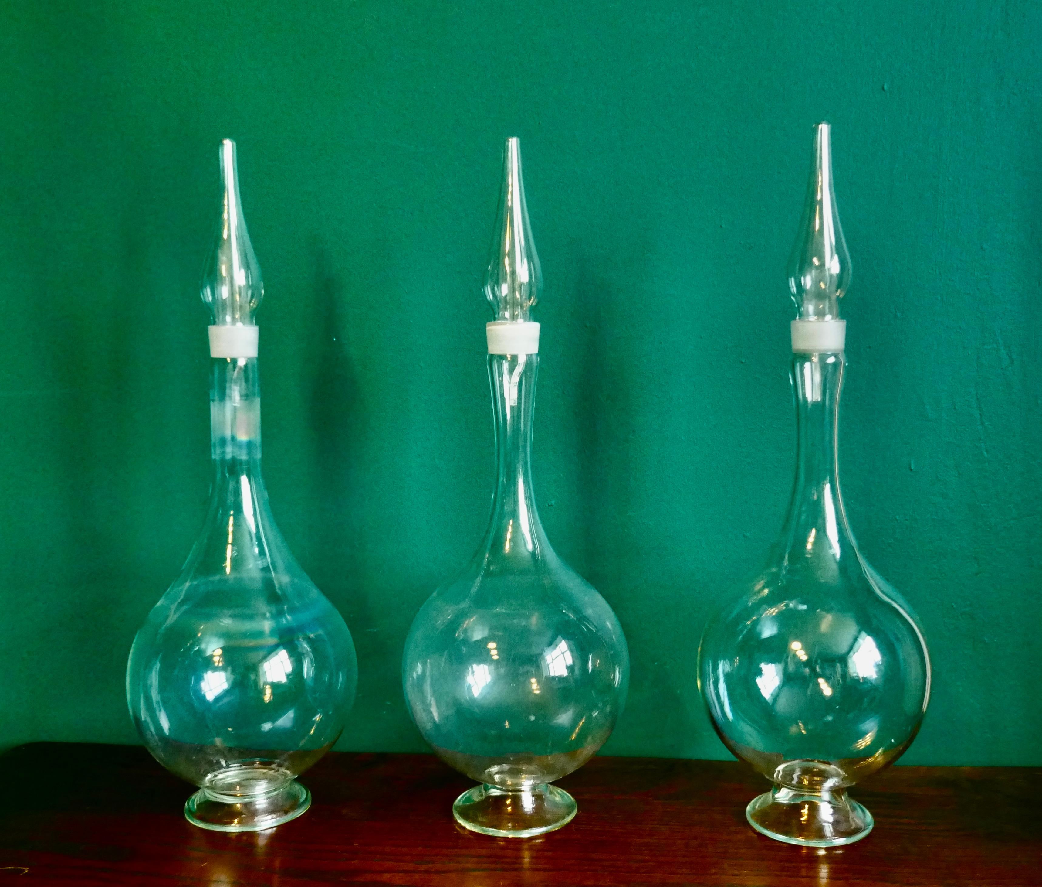 3 Very Large Antique Apothecary or Old Chemist Jars Shop Display  

These superb large jars are hand blown clear glass, they would have stood on a top shelf of the chemist shop
The jars have deep round bowls, a long neck and a pointed top