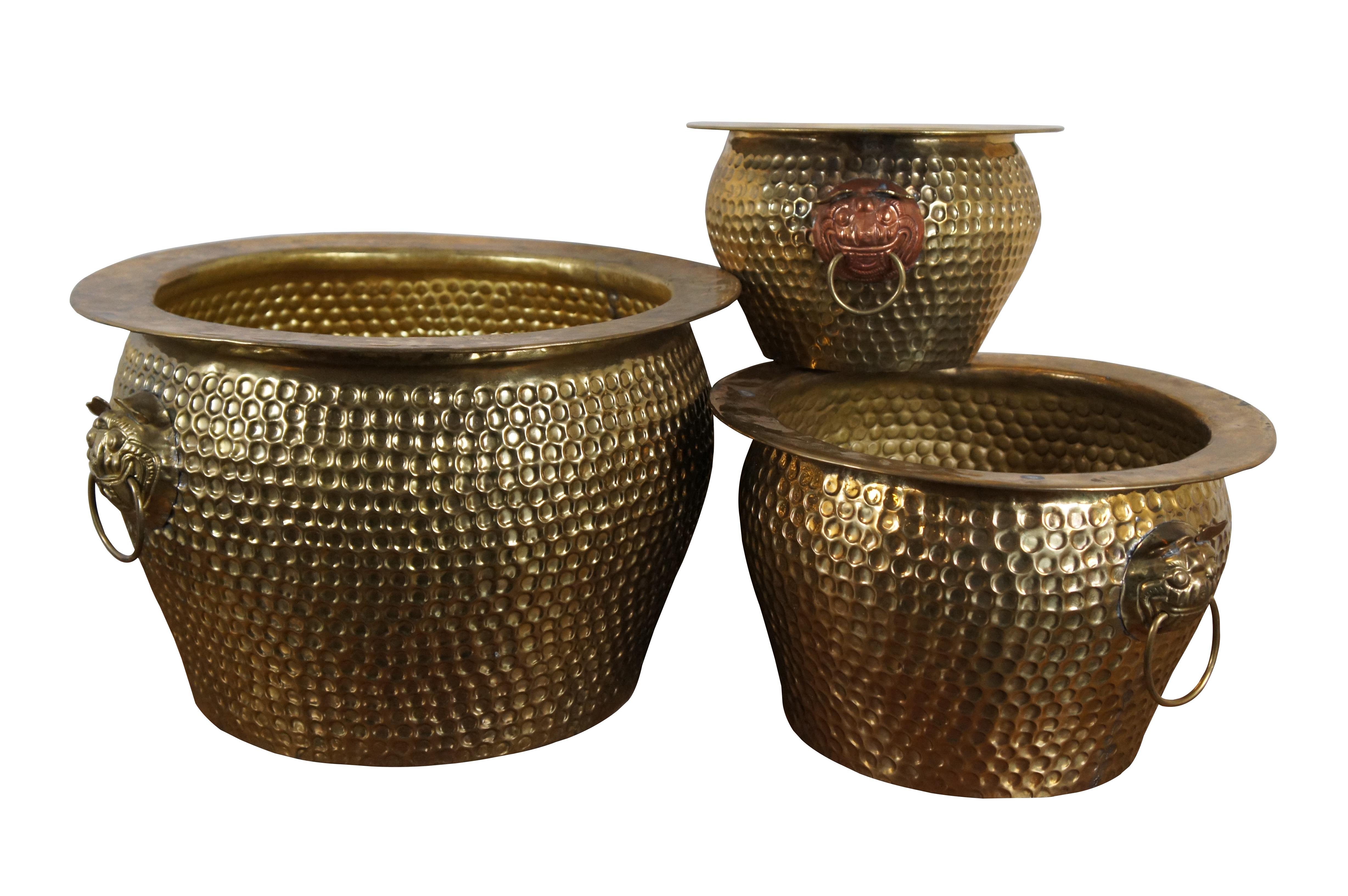 Three vintage Chinese nesting planters / jardinieres / cachepots with original box.  Made of brass featuring round form with hammered dovetailed body that features foo dog / dragon / lion ring handles.  The smallest one has copper ring