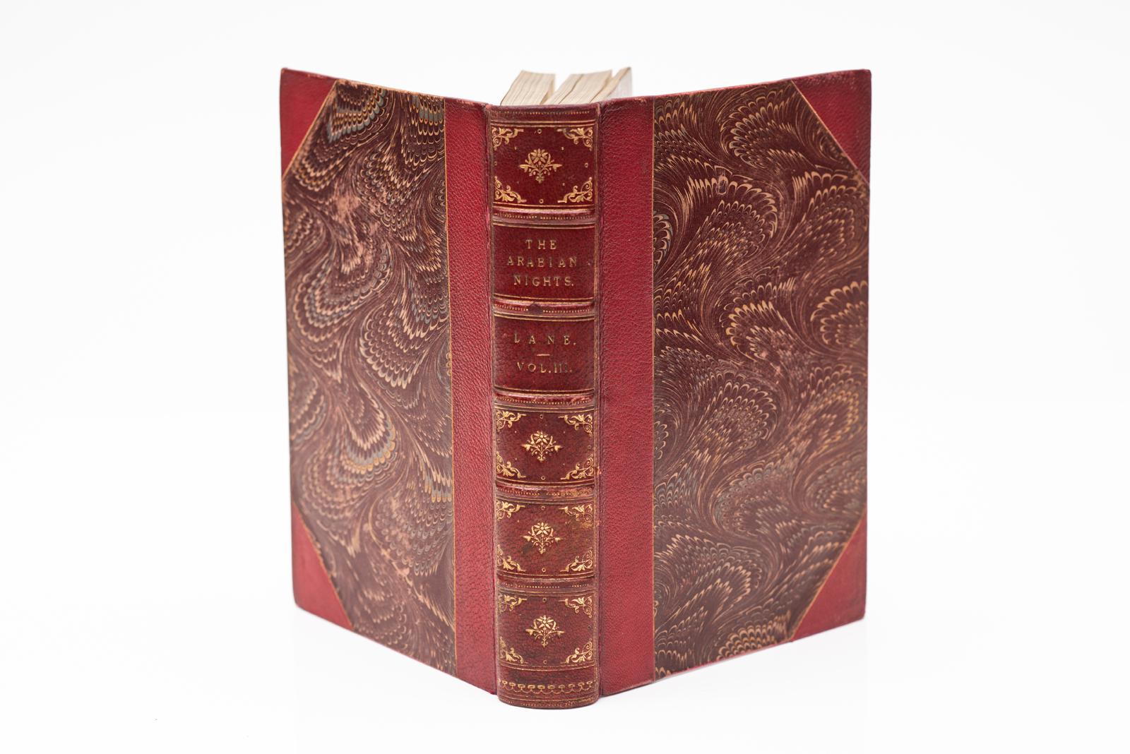 3 Vols. Edward Williams Lane, Les Mille et une nuits. Illustré, relié en 3/4 maroquin rouge, plats et gardes marbrés, tous bordés de doré, bandes en relief, panneaux dorés. Publié : Londres, Bickers & Son 1877.
H : 9