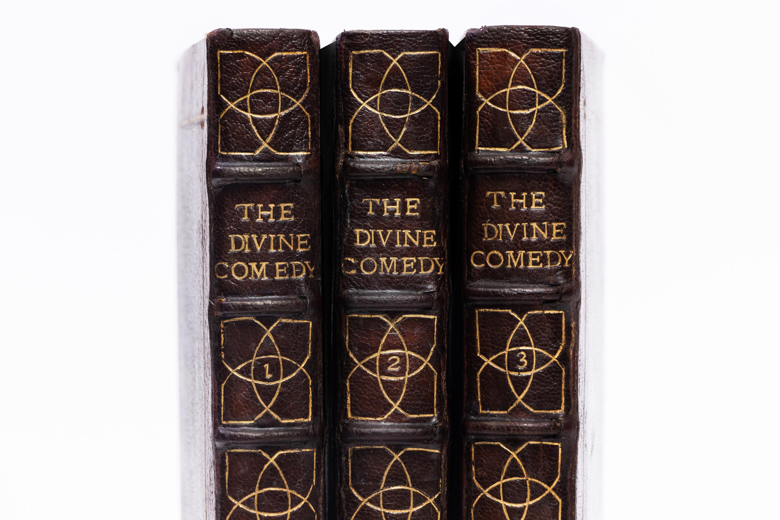 3 Volumes. Dante Alighieri, The Divine Comedy. Bound in full brown morocco. Gilt tooling on covers. Raised bands. Decorative gilt tooled symbols on spines. All edges colored in green. Illustrated. Translated by Charles Eliot Norton. Published: New