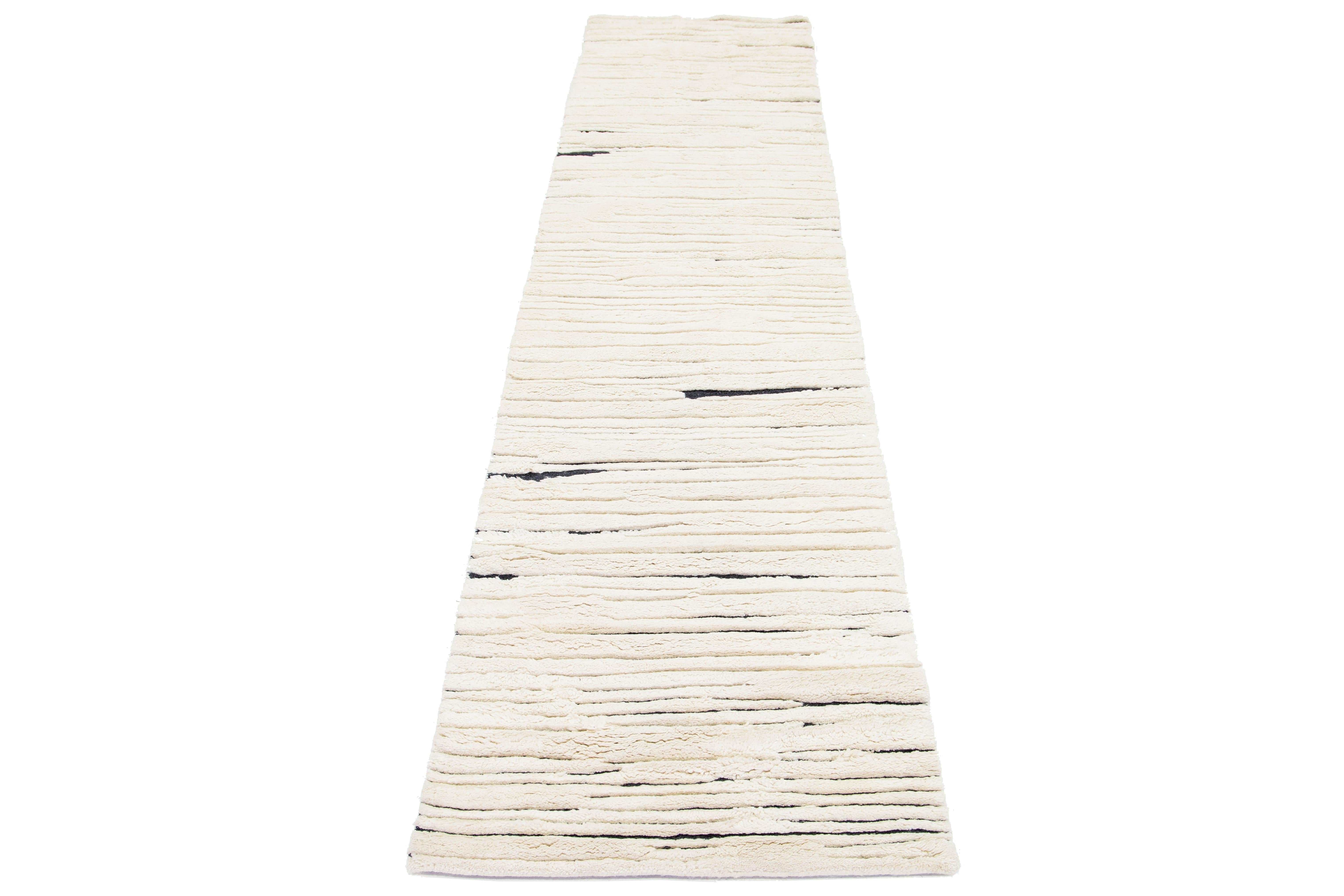 This exquisite, handmade wool rug showcases a beautiful Moroccan style, featuring a deep gray-charcoal field. Adorned with elegant ivory accents, it features an enchanting all-over geometric design that brings a modern flair to any room.

This rug