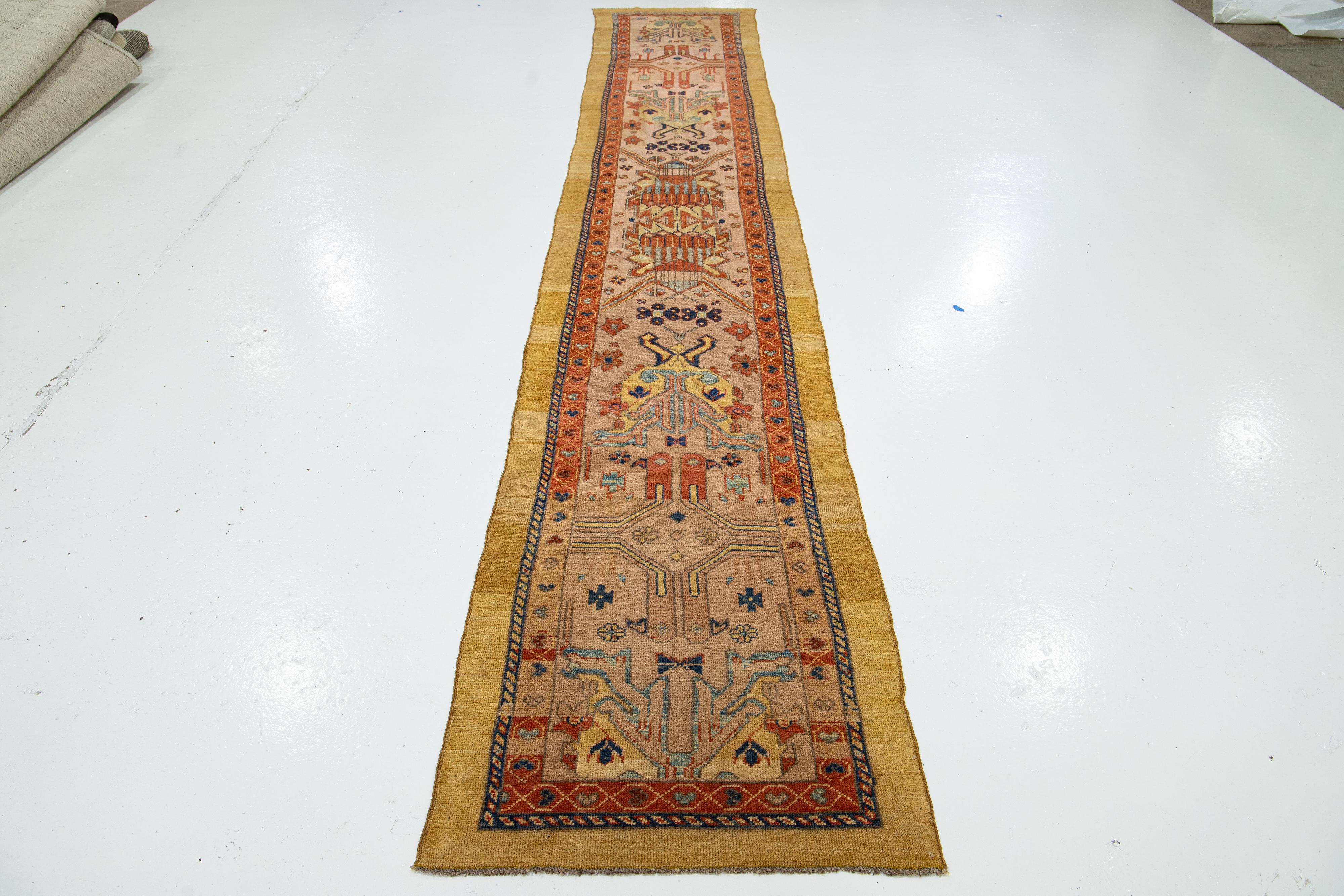 Experience the timeless elegance of a North West Persian hand-knotted wool rug. This runner is part of our Revival Collection and features a striking peach field complemented by multi-color accents, all woven into an intricate all-over geometric