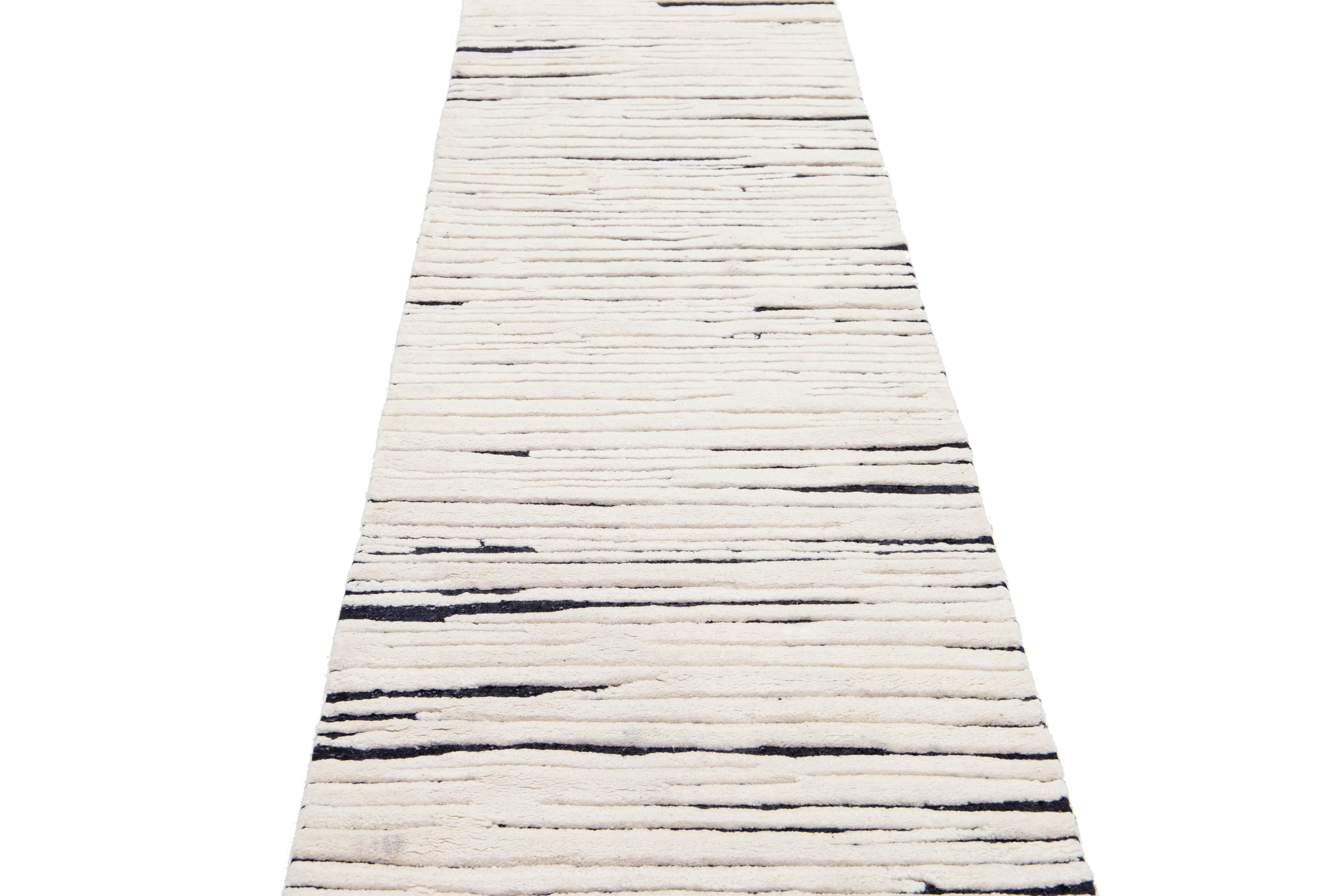 This exquisite, handmade wool rug showcases a beautiful Moroccan style, featuring a deep gray-charcoal field. Adorned with elegant ivory accents, it features an enchanting all-over geometric design that brings a modern flair to any room.

This rug