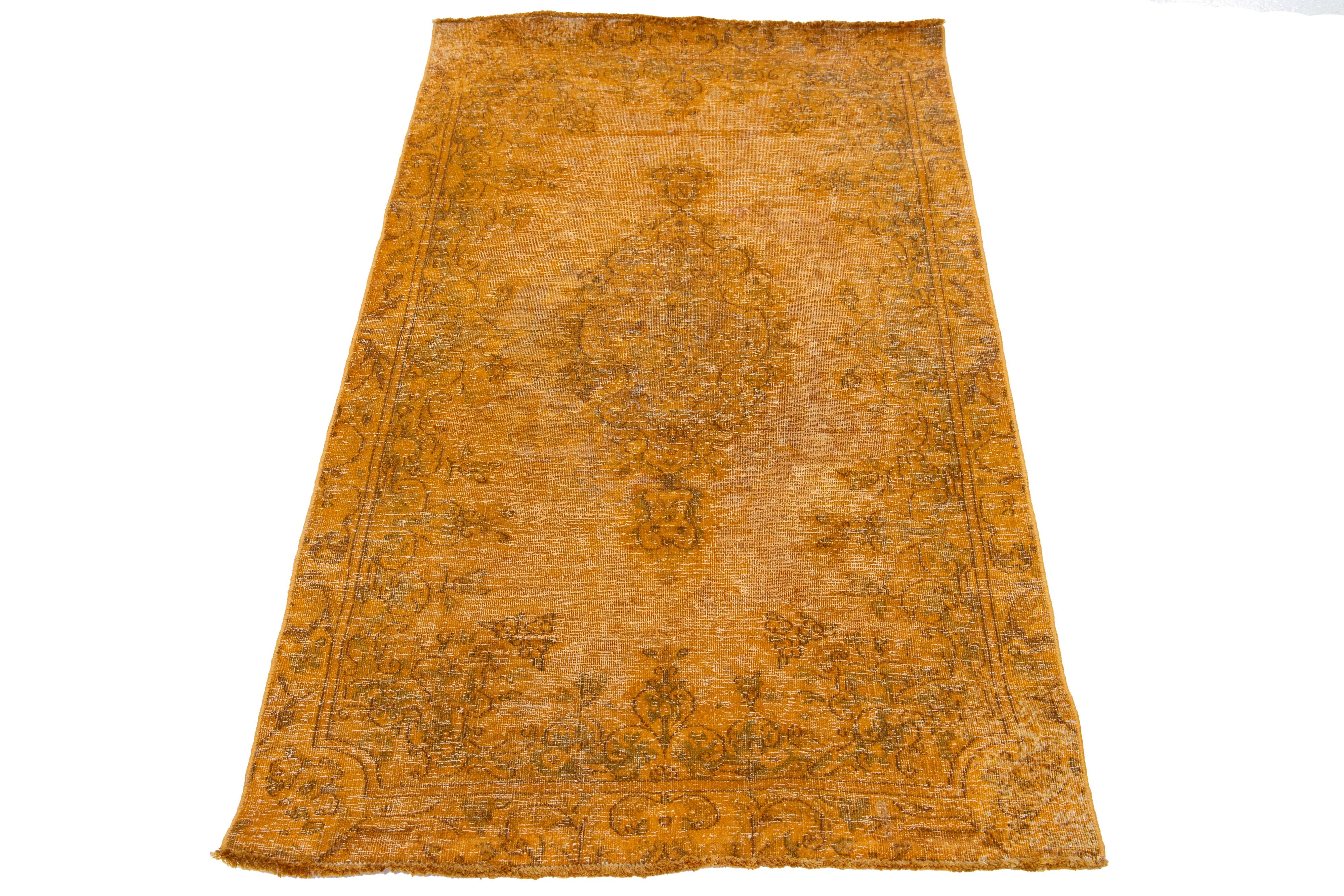 Ce tapis vintage en laine persane surteinte présente un champ orange captivant avec de charmants accents floraux gris.

Ce tapis mesure 2'7
