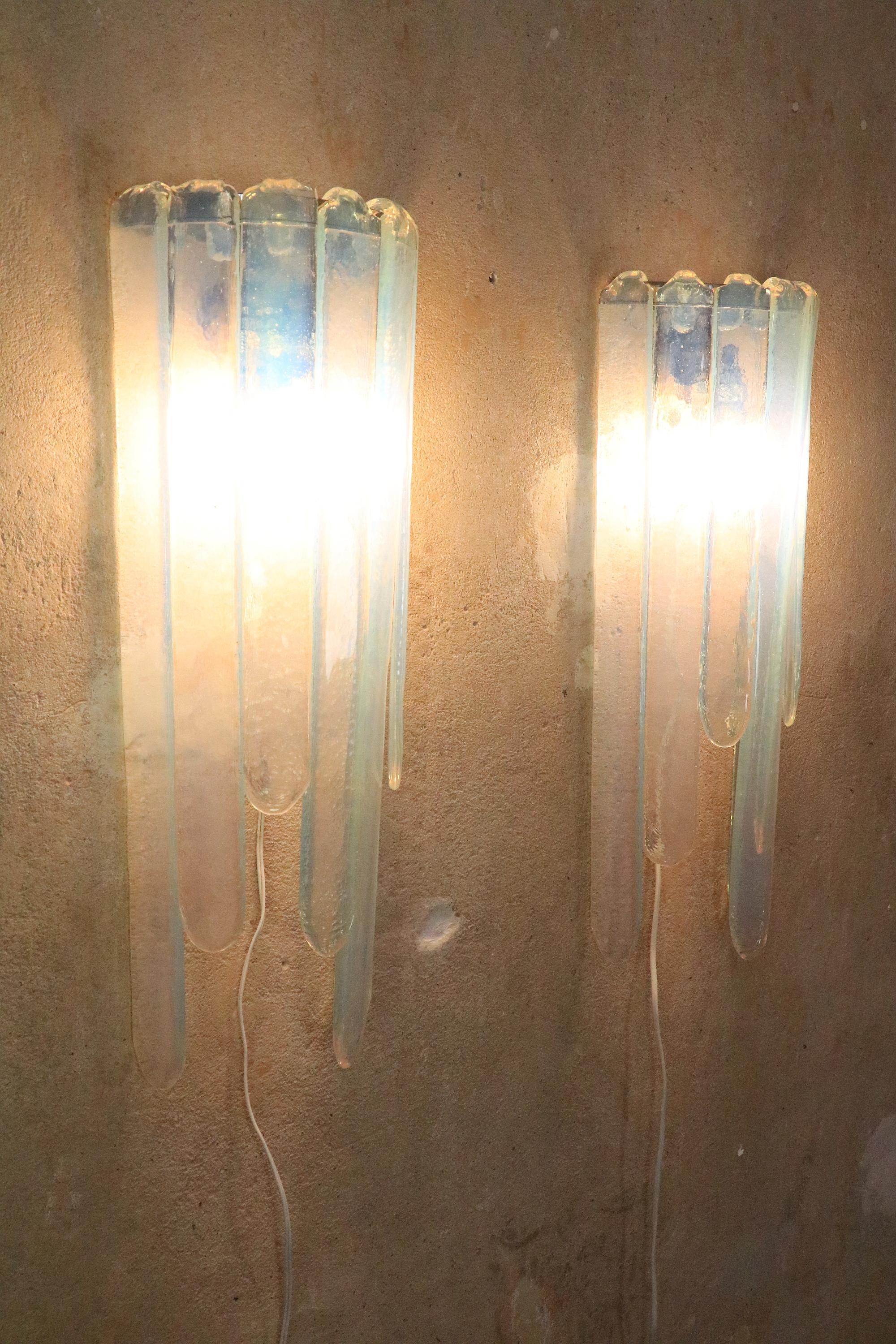 One of two very rare ice blue Murano glass wall lamps.
Design: Carlo Nason for Mazzega
 
Cascading glass rods arranged at different heights, simply hung in a frame. Seven rods per frame.
Exceptional color.
 
Very well preserved. New sockets and