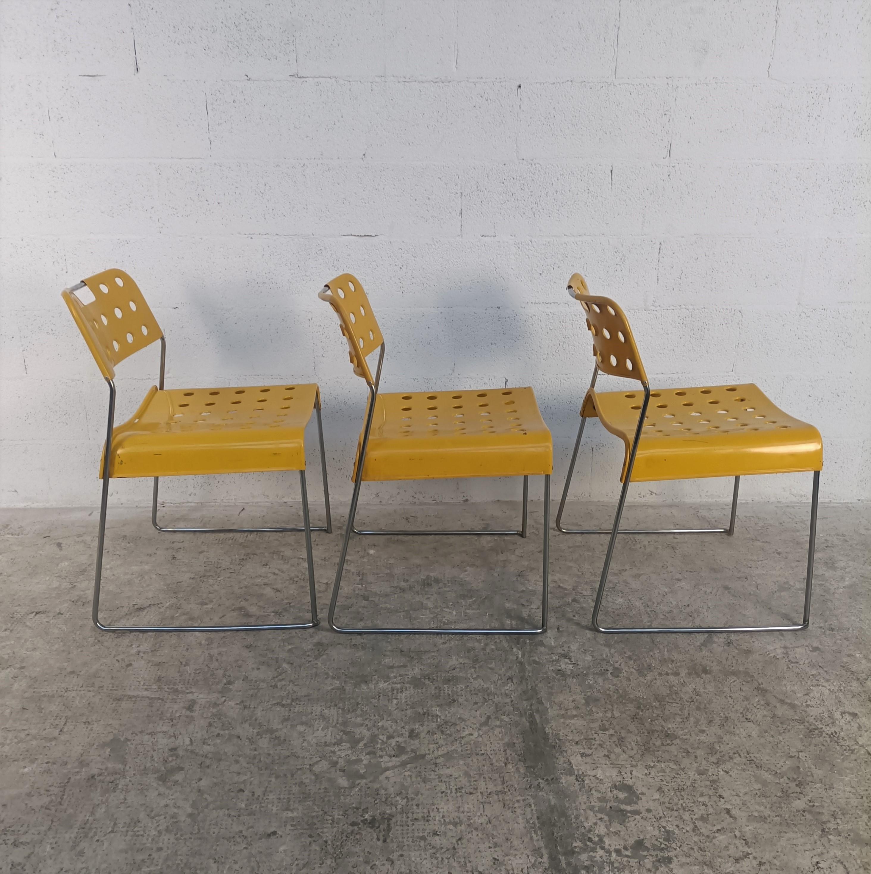 3 Chaises à manger en métal modèle Omkstak conçues par Rodney Kinsman et produites par Bieffeplast 1970.
Structure en acier tubulaire chromé, assise et dossier en tôle d'acier moulée et revêtue de résine époxy jaune. Les détails perforés rendent la