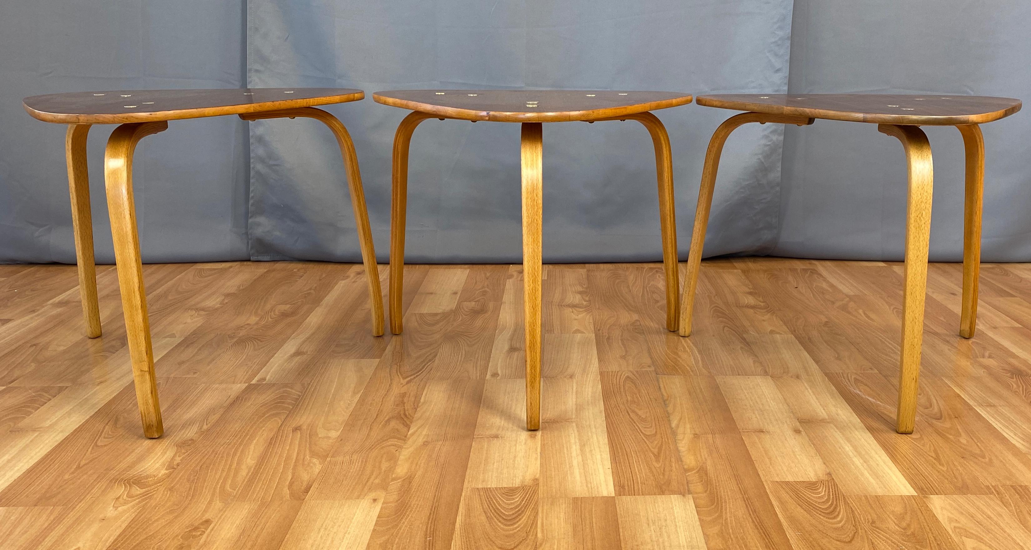 Three small tables is the shape of guitar picks, designed by Yngve Ekström for DUX of Sweden.
Three bent wood legs on each table, that most likely are Beech, each leg is attached to the tops with brass hardware.
Tops are rounded triangles, with