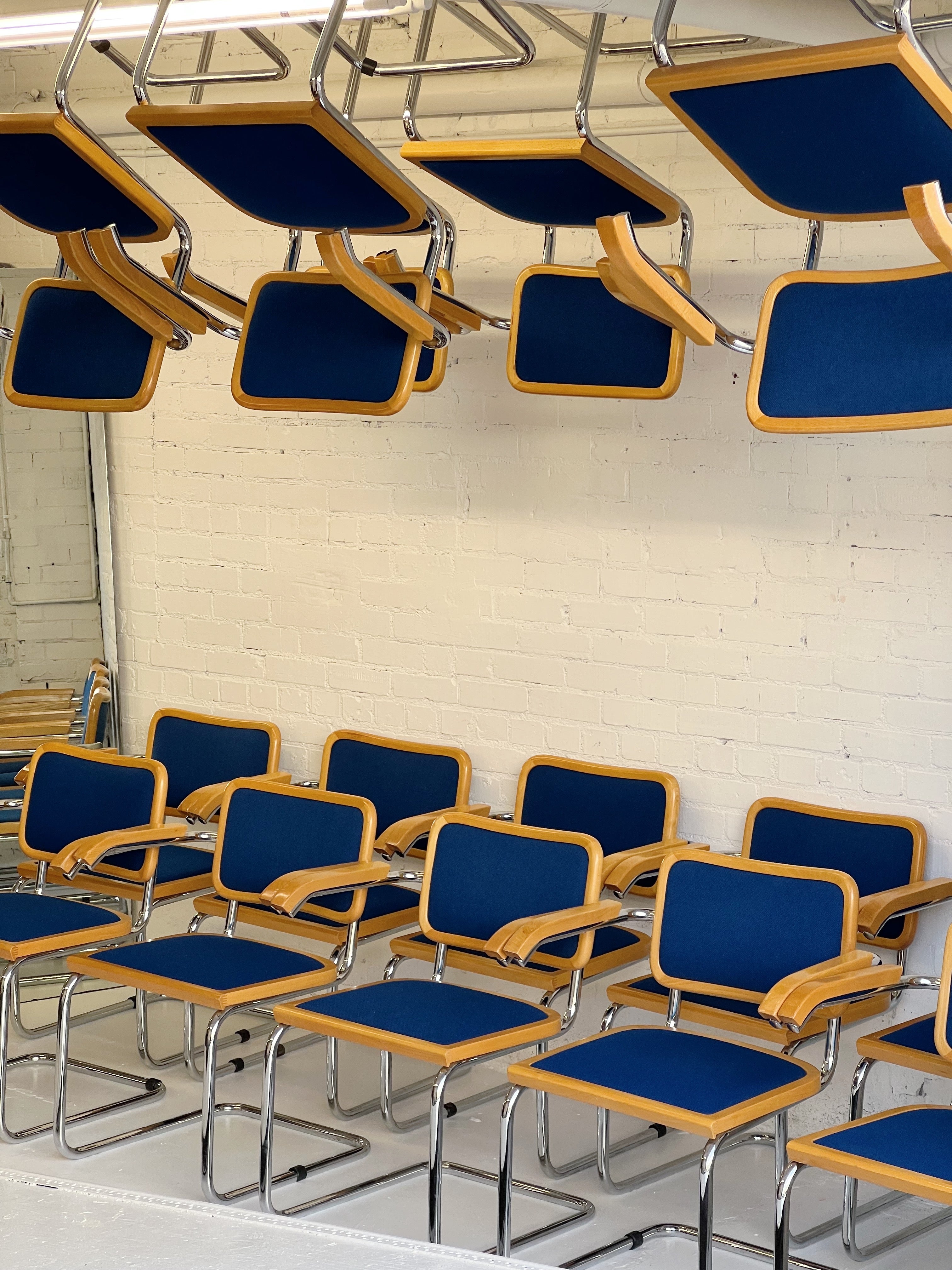 1980's Cecsa style dining chairs by Loewenstein. Rare cobalt blue upholstery with chrome frames, upper wood trim, and armrests. 30 available. All have armrests.

These were produced in 1983-1985 and have spent their days in a YWCA training center in