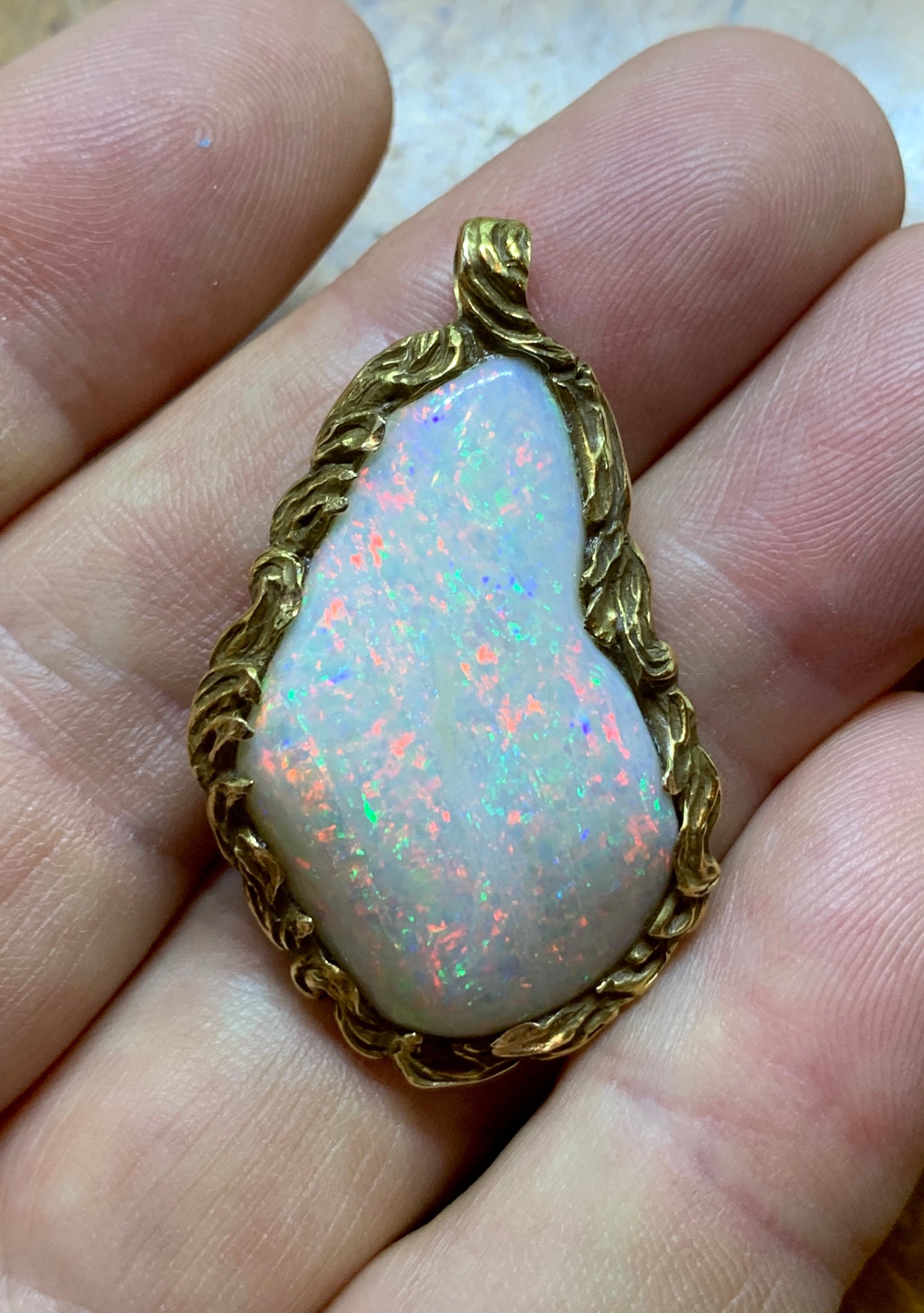 This is an absolutely spectacular 30 Carat Fire Opal Pendant in a stunning Flame Motif setting in 14 Karat Gold.  The extraordinary opal is 1 3/8 inches tall and is 7/8 inch wide.  The opal has magnificent fire with an exuberance of red throughout