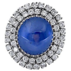 Bague cocktail avec saphir bleu cabochon 30 carats et double halo de diamants