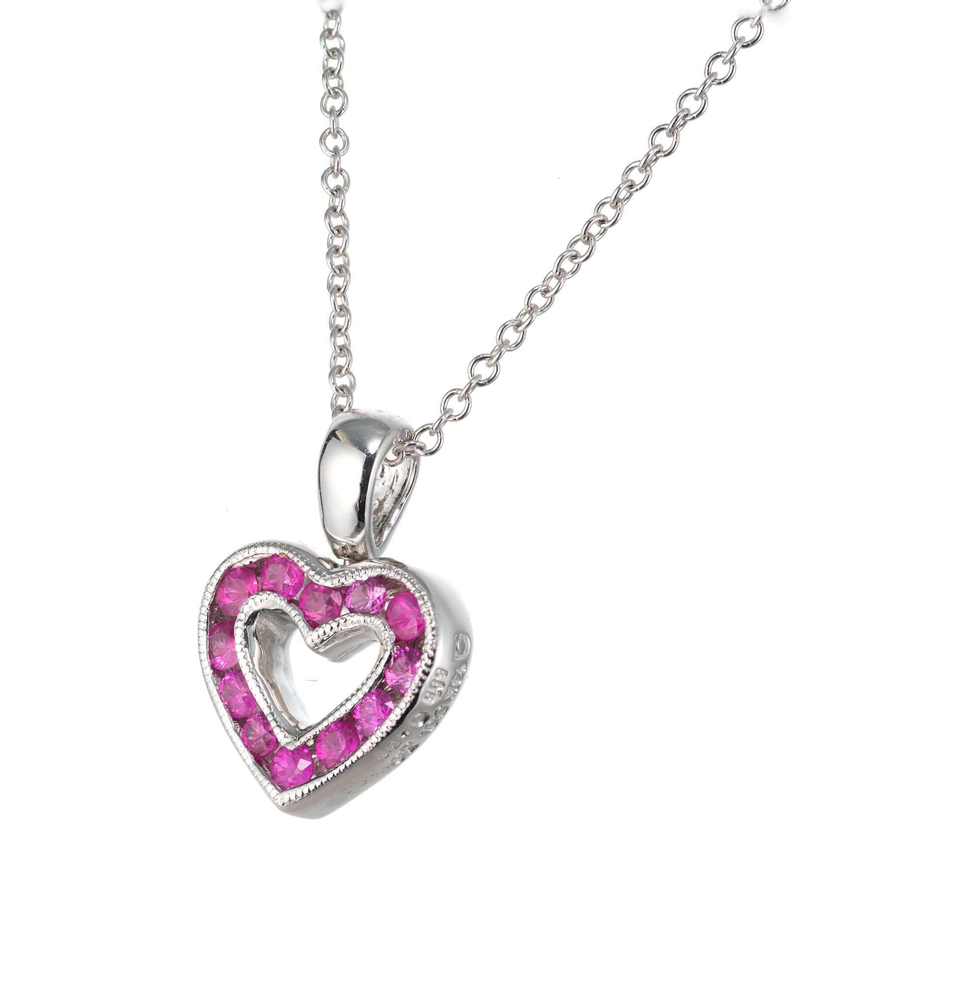 Petite reversible diamond and pink sapphire open-heart pendant in 14k white gold. Chain, 16.5 inches in length. 

12 round brilliant cut diamonds, H-I SI-I approx. .30cts
12 round pink sapphires, approx. .35cts
14k white gold 
Stamped: 14k
2.7