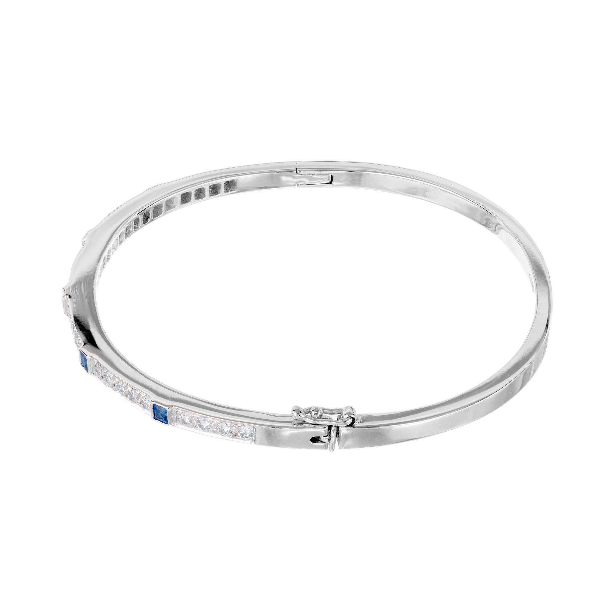 Hinged 18k white gold bangle bracelet with built in catch and side lock safety. Set with square sapphires in bezels and round pave set diamonds.  Fits a 7-7.5-inch wrist

5 square cut blue sapphires, .15cts
28 brilliant round cut diamonds, G-H VS