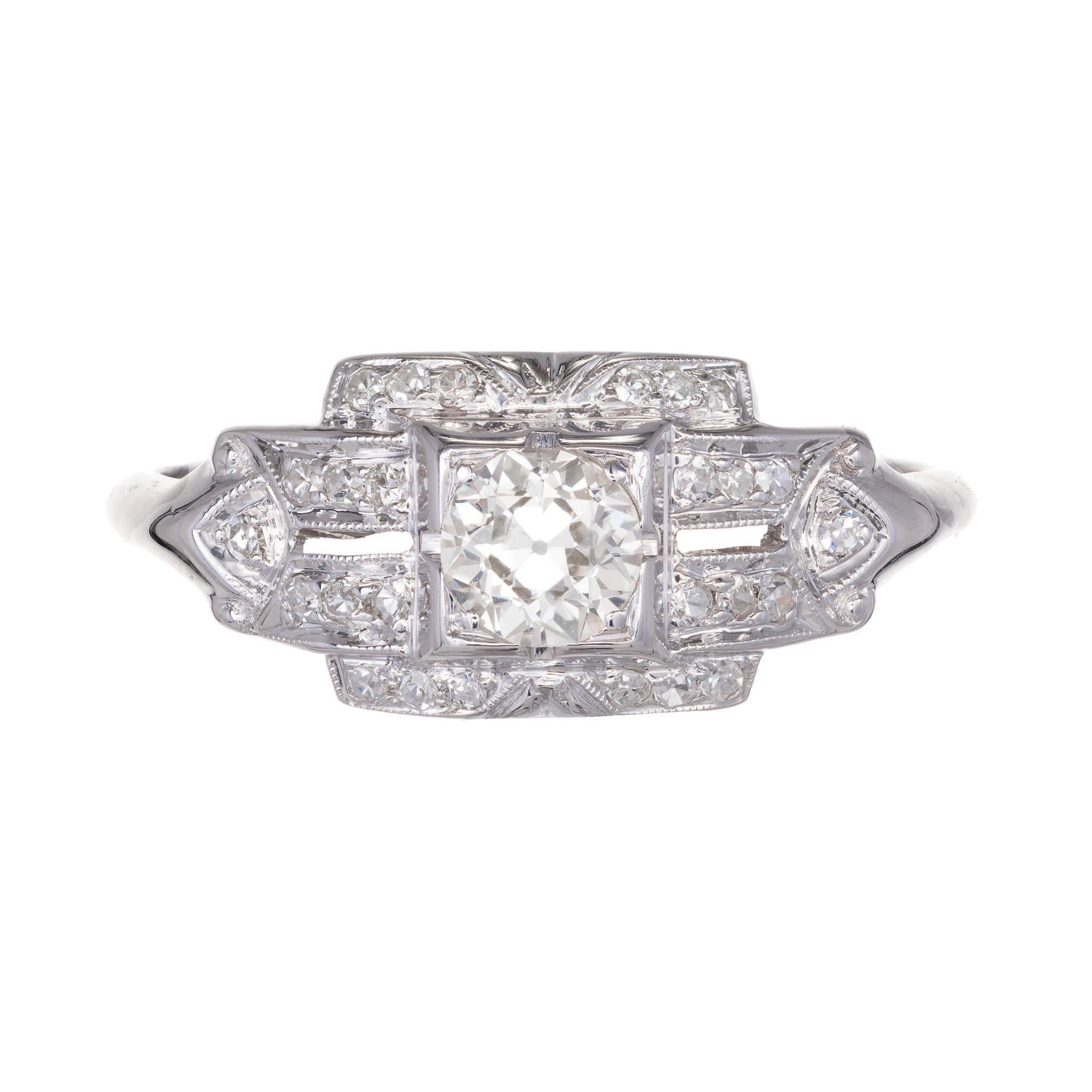 Art Deco diamond engagement ring. Center round diamond set in square setting with geometric designs set with round diamonds to the sides and top and bottom.

1 round Old European Q-R VS2 diamond approximate .30 carat. EGL Certificate: